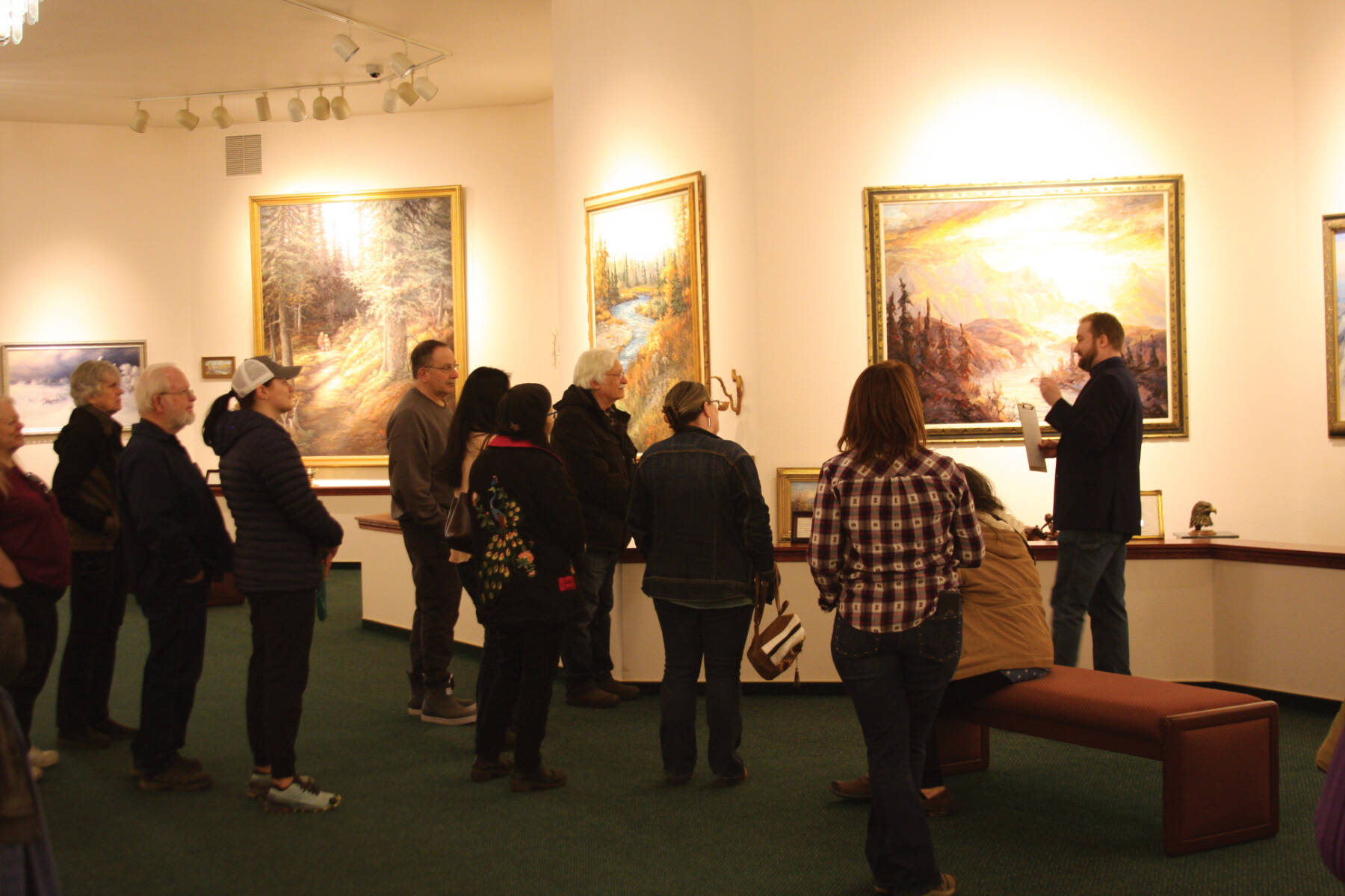 Curator Barnabas Firth (right) tells stories of artworks by Norman Lowell to attendees of the invitational gathering on Saturday, April 29, 2023 at the Norman Lowell Art Gallery in Anchor Point, Alaska. Photo by Delcenia Cosman