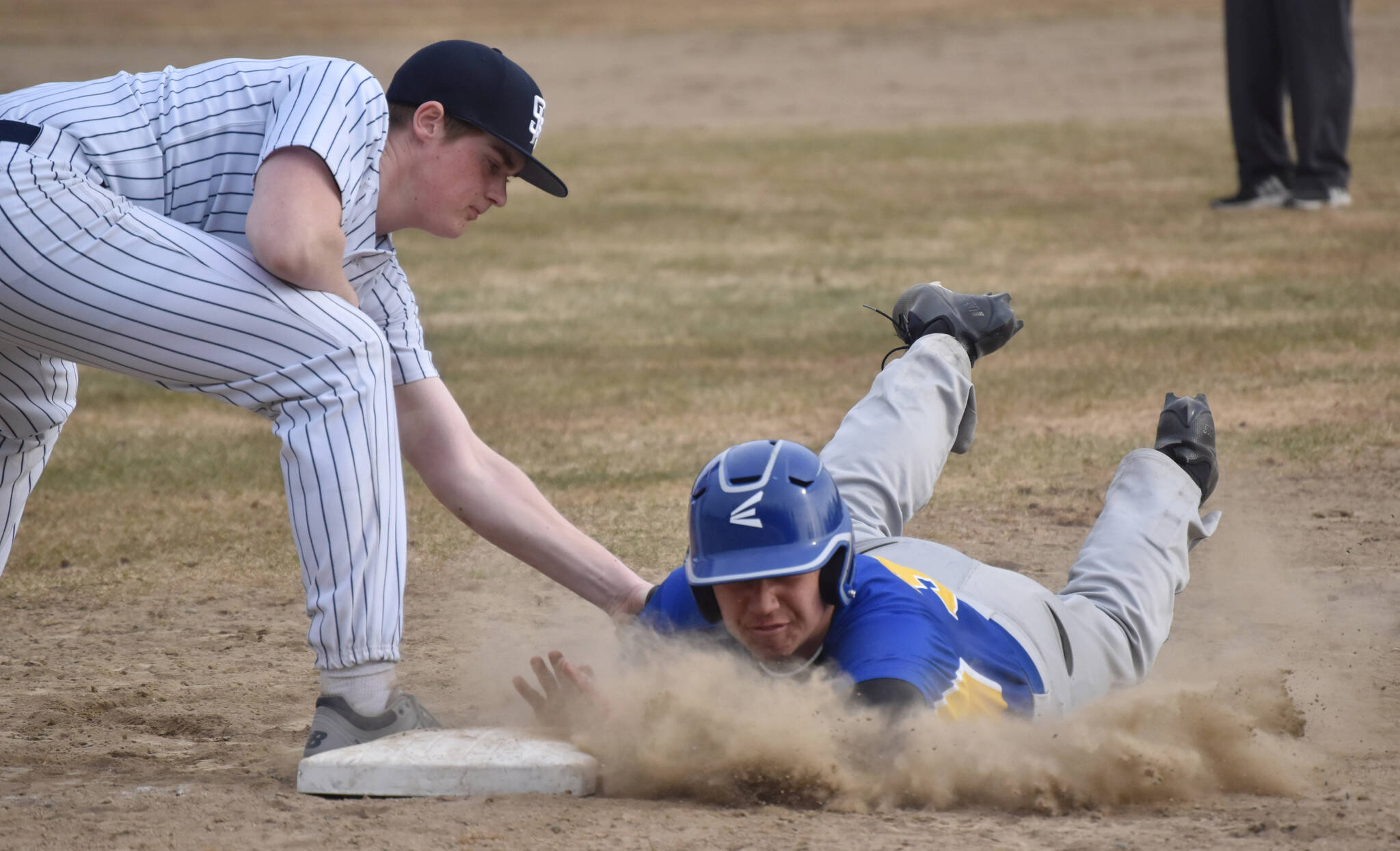 Kodiak’s Robert Anderson slides under the tag of Soldotna’s Wyatt Gagnon on Friday, May 5, 2023, at the Soldotna Little League fields in Soldotna, Alaska. (Photo by Jeff Helminiak/Peninsula Clarion)