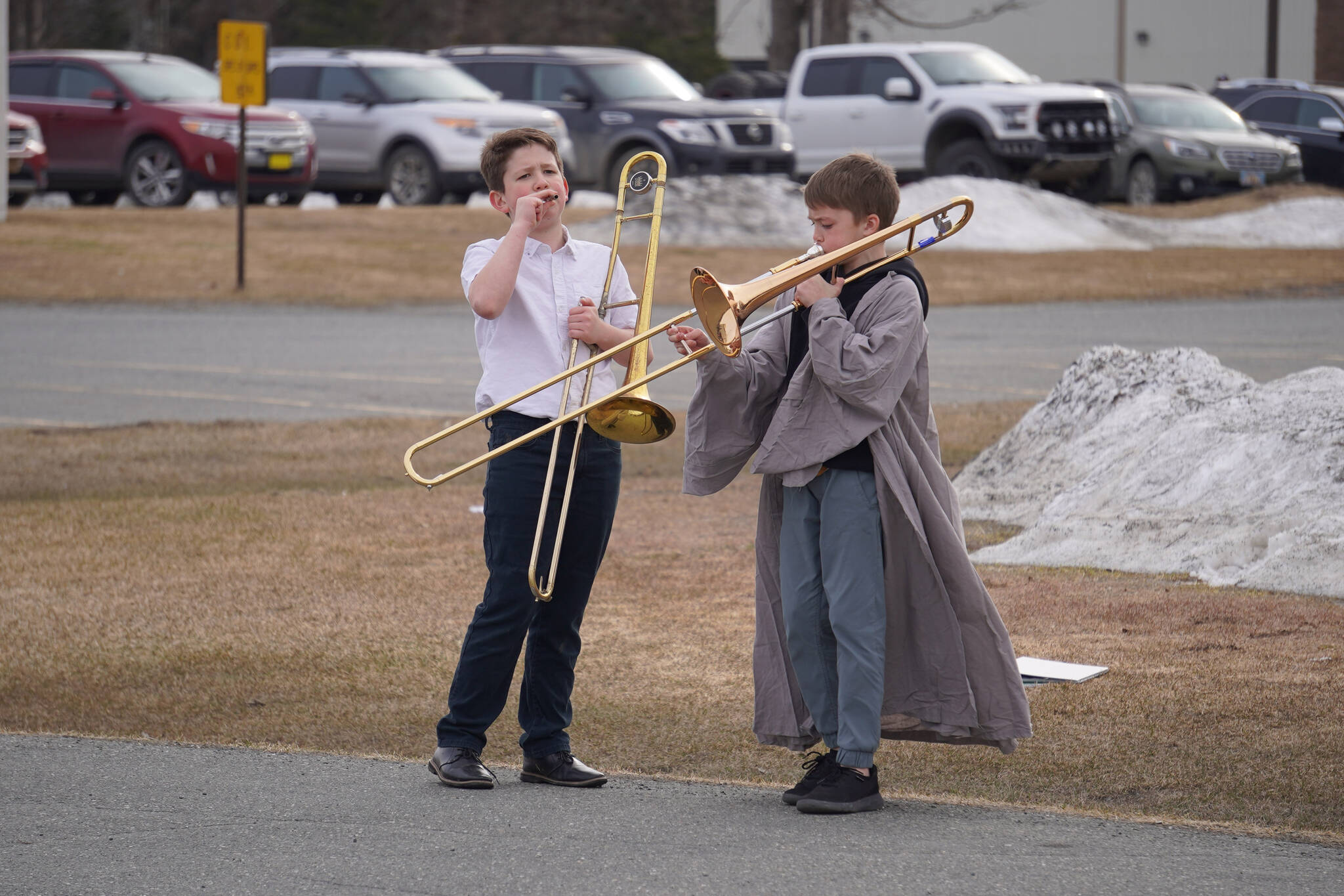 A trombone player in the robes of a jedi warms up during Pops in the Parking Lot at Kenai Central High School in Kenai, Alaska, on Thursday, May 4, 2023. (Jake Dye/Peninsula Clarion)