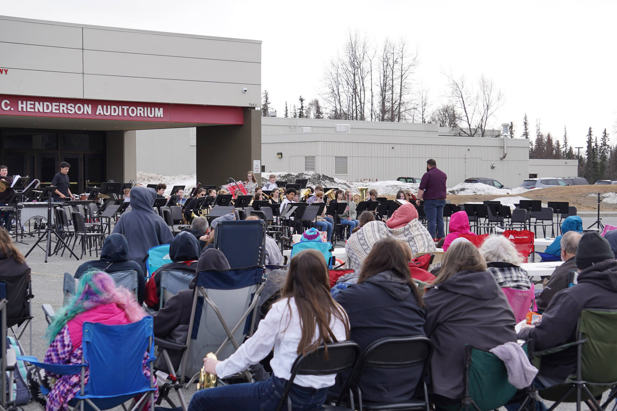 The Kenai Middle School Band performs in front of a crowd in winter jackets during Pops in the Parking Lot at Kenai Central High School in Kenai, Alaska, on Thursday, May 4, 2023. (Jake Dye/Peninsula Clarion)