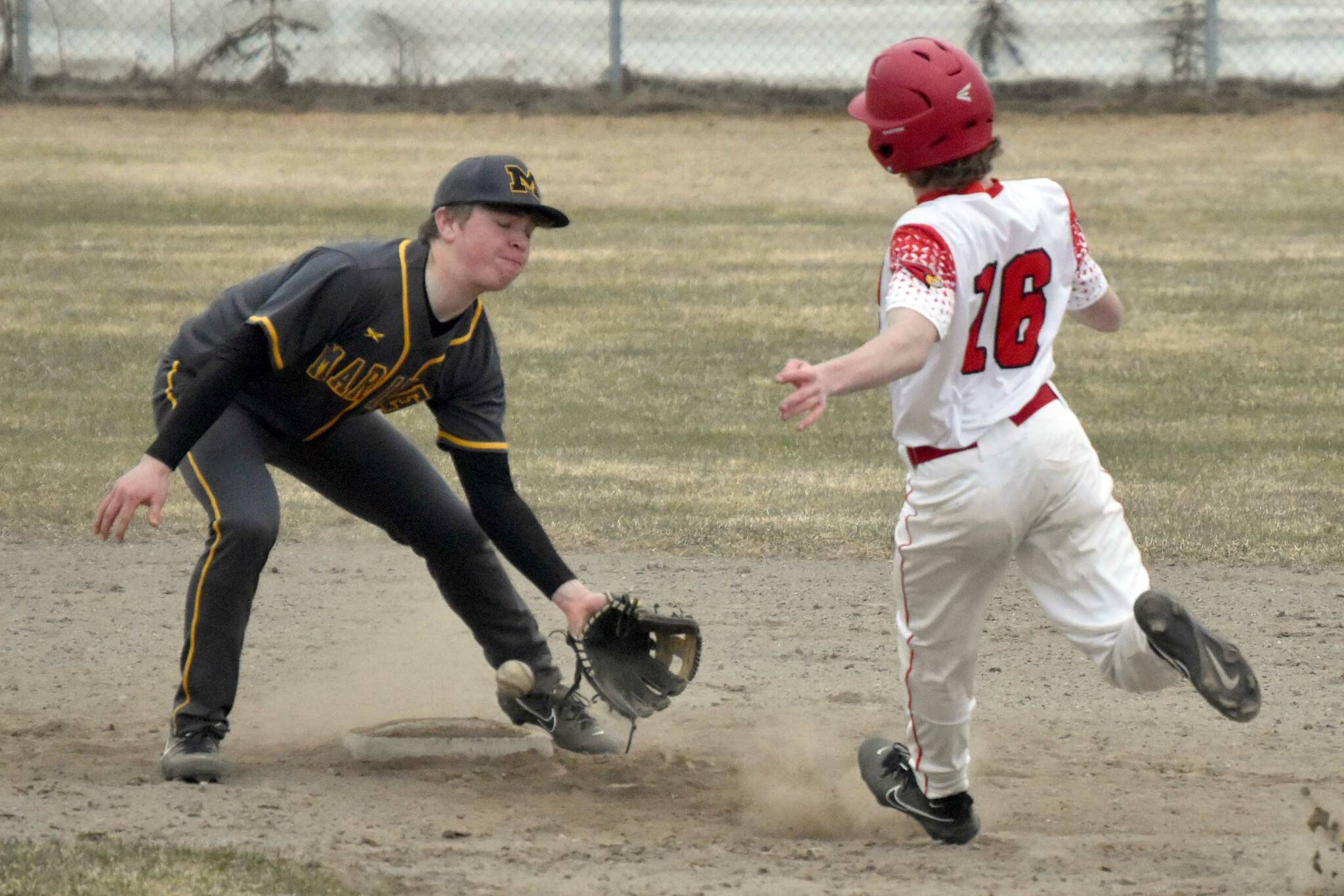 Kenai Central's Avery Martin arrives safely at second base in front of Homer second baseman Preston Stanislaw on Tuesday, May 9, 2023, at the Kenai Little League fields in Kenai, Alaska. (Photo by Jeff Helminiak/Peninsula Clarion)