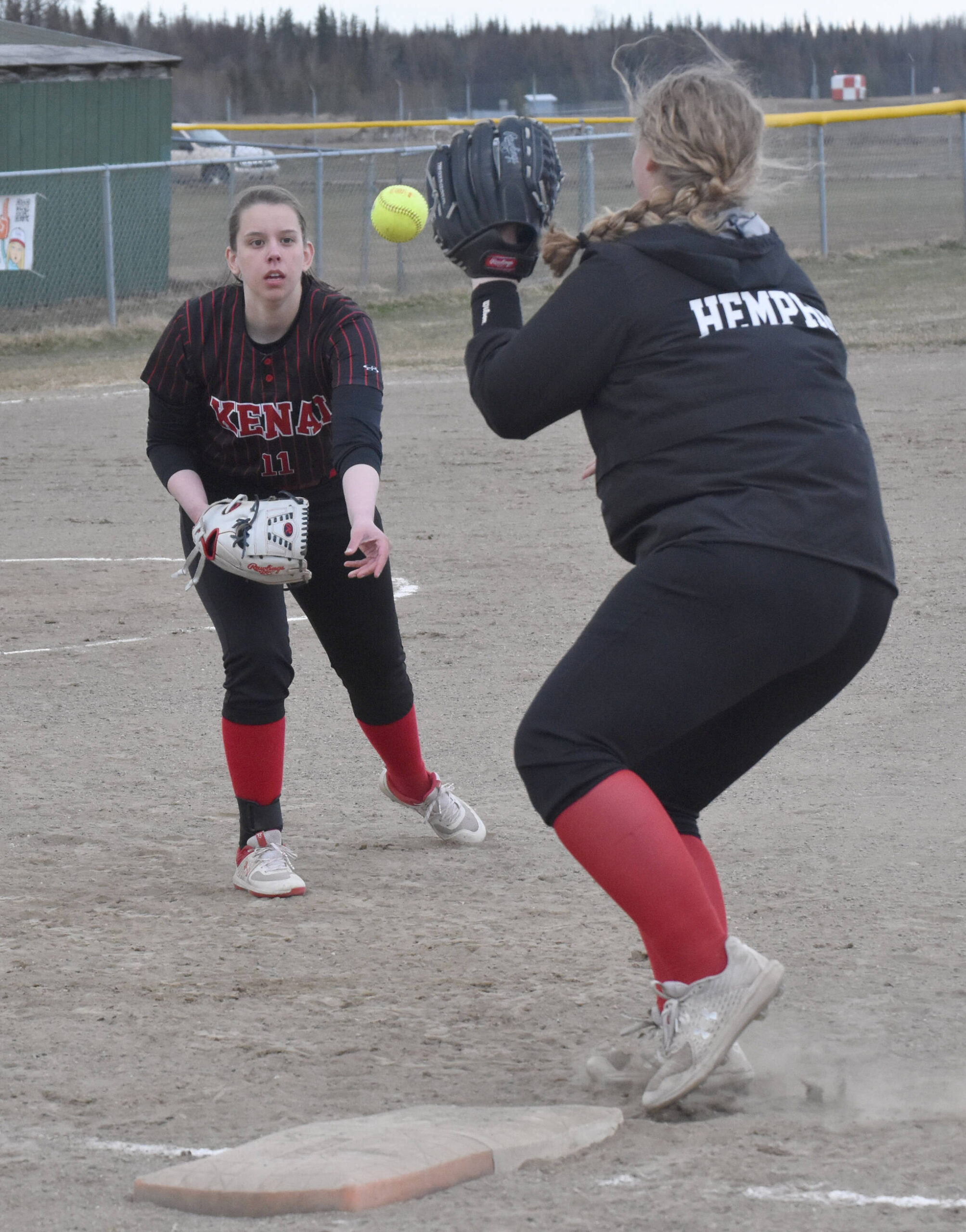 Kenai Central first baseman Izzie Katzenberger shovels to second baseman Shelby Hemphill for an out against Houston on Thursday, May 11, 2023, at the Steve Shearer Memorial Ball Park in Kenai, Alaska. (Photo by Jeff Helminiak/Peninsula Clarion)