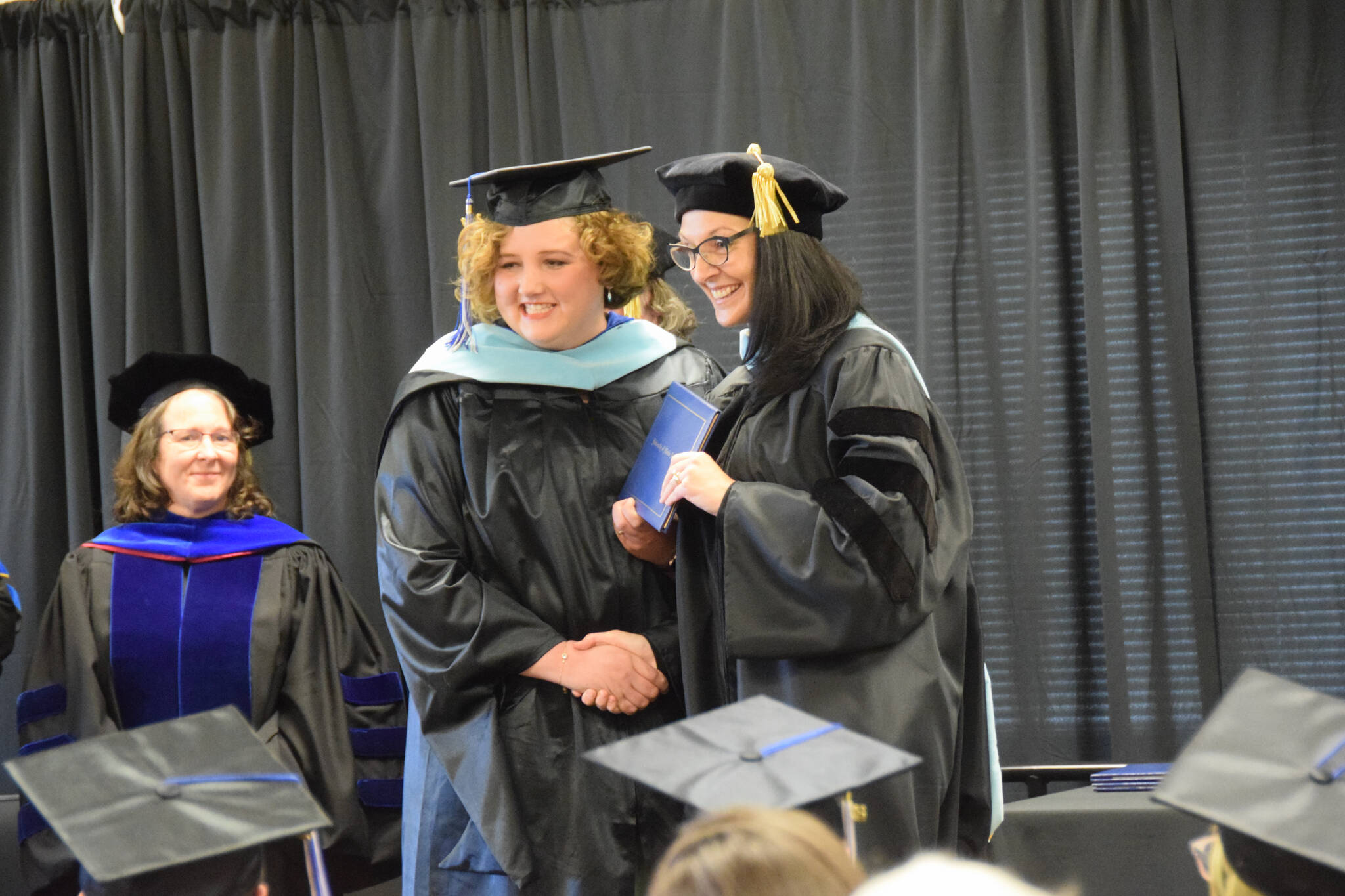 University of Alaska Southeast’s Dr. Christine Ermold (right) presents Rachel Ostler with her diploma and master’s hood during the 2023 KBC Commencement on Wednesday, May 10, 2023 in Homer, Alaska. Ostler completed her Master of Arts degree in Education through UAS. (Photo by Delcenia Cosman/Homer News)