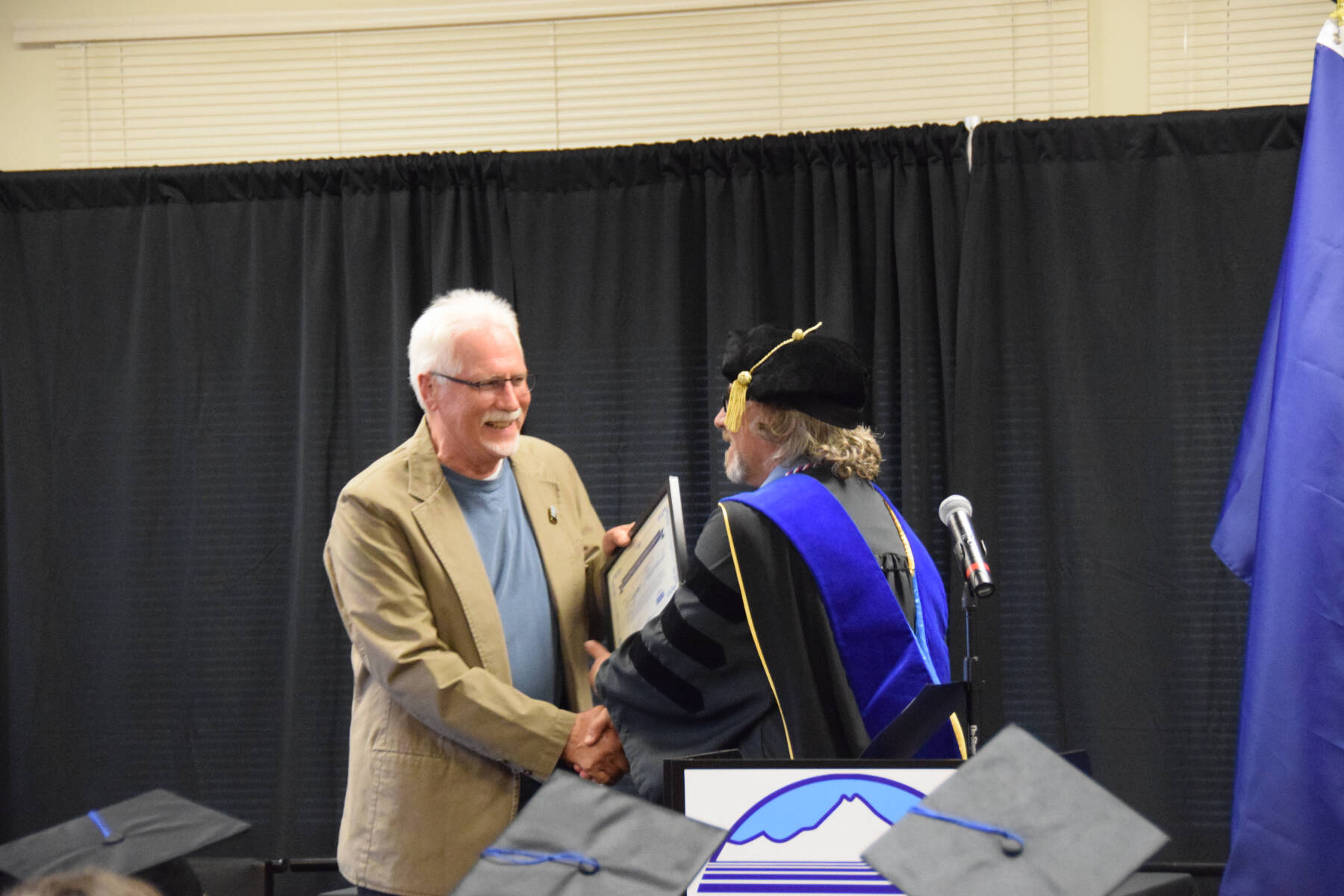Kachemak Bay Campus Director Dr. Reid Brewer (right) presents the KBC Director’s Choice award to KBC advisory board member and student Wayne Aderhold (right) during the 2023 KBC Commencement on Wednesday, May 10, 2023, in Homer, Alaska. (Photo by Delcenia Cosman/Homer News)