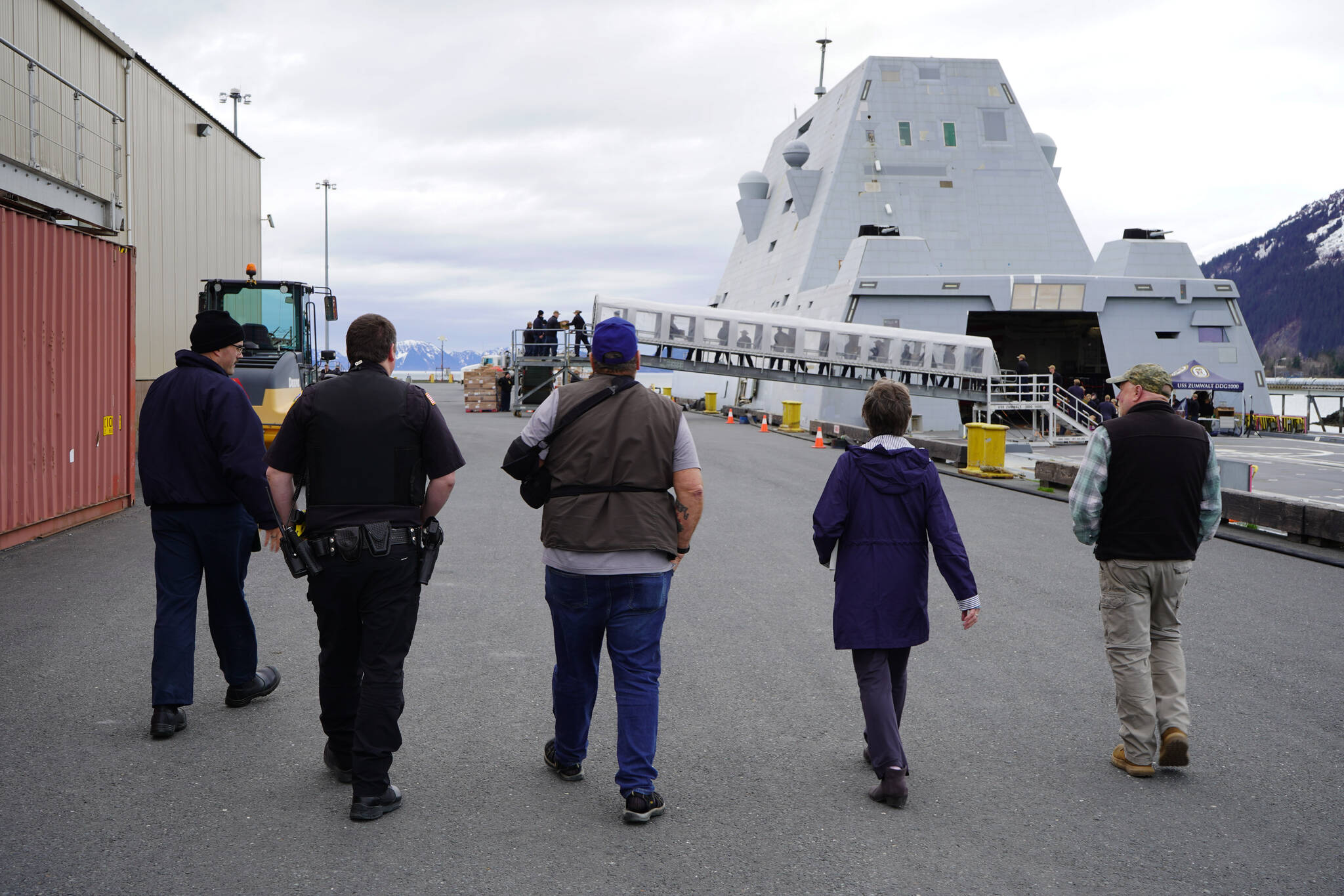 Lt. j.g. William Ash leads Deputy Police Chief Karl Schaefermeyer, Harbormaster/Acting City Manager Norm Regis and Seward Mayor Sue McClure to the USS Zumwalt on Friday, May 12, 2023, in Seward, Alaska. (Jake Dye/Peninsula Clarion)