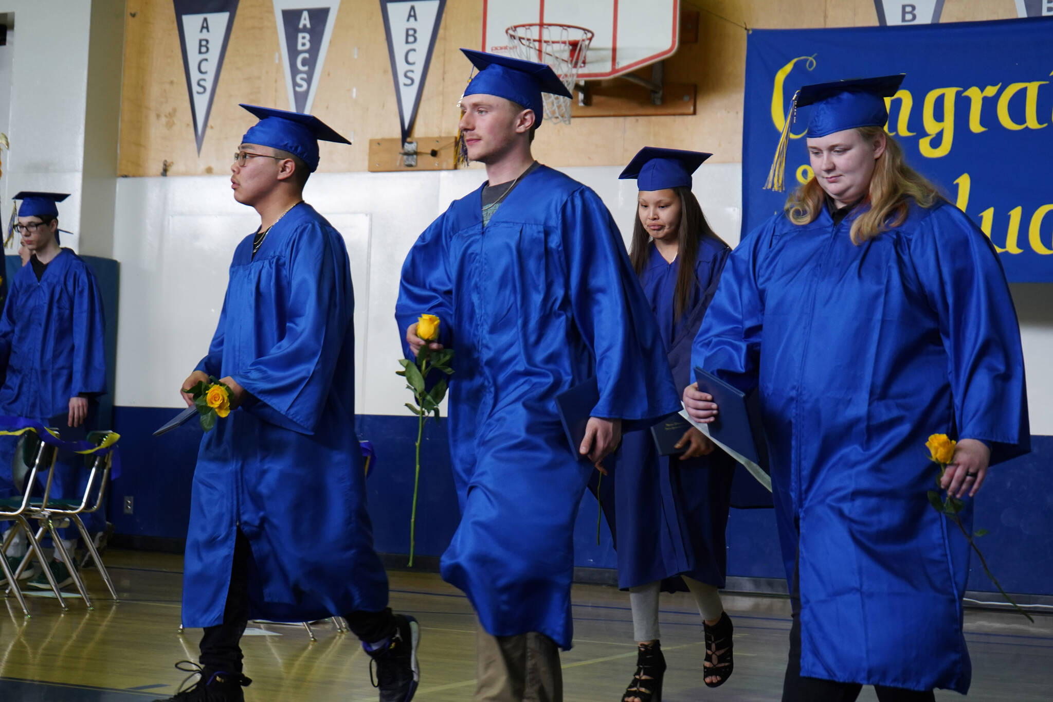 Kenai Alternative High School graduates deliver roses to their supporters during a graduation ceremony on Monday, May 15, 2023, at Kenai Alternative High School in Kenai, Alaska. (Jake Dye/Peninsula Clarion)