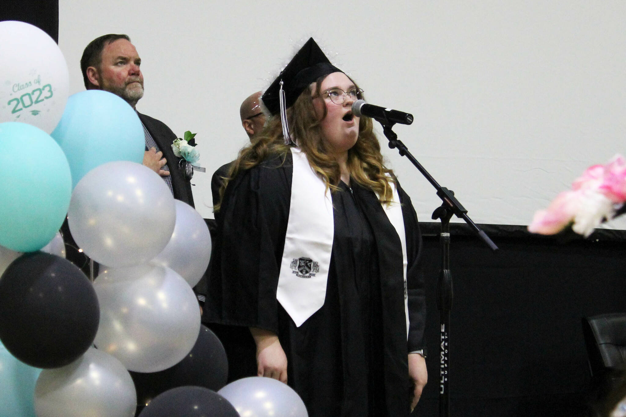 Nikiski Middle/High School graduate Adrienne Muir sings the national anthem during a ceremony on Tuesday, May 16, 2023, in Nikiski, Alaska. (Ashlyn O’Hara/Peninsula Clarion)