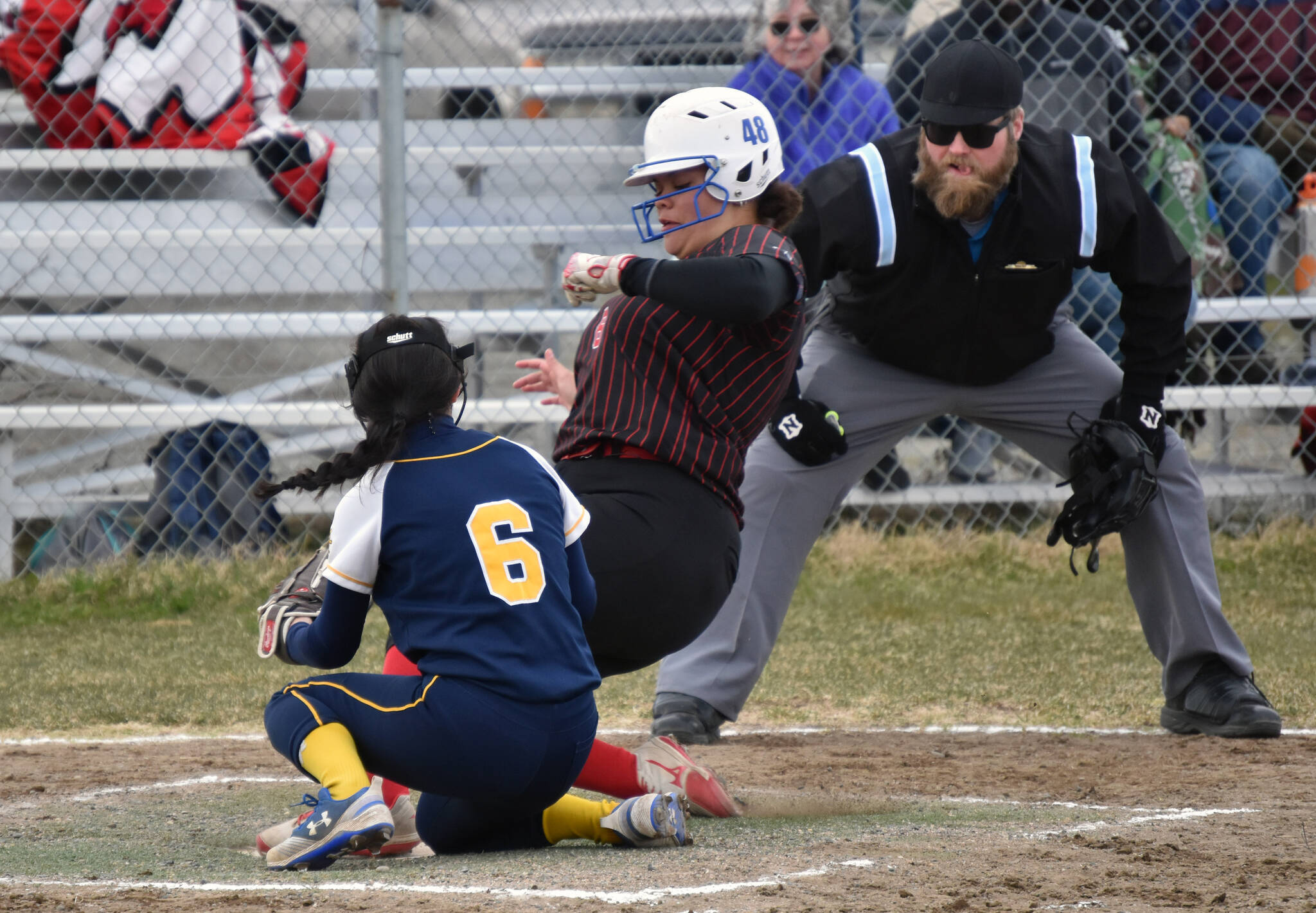 Kenai Central’s Kyana Griskevich scores in front of Homer’s Ariana Davis on Tuesday, May 16, 2023, at Steve Shearer Memorial Ball Park in Kenai, Alaska. (Photo by Jeff Helminiak/Peninsula Clarion)