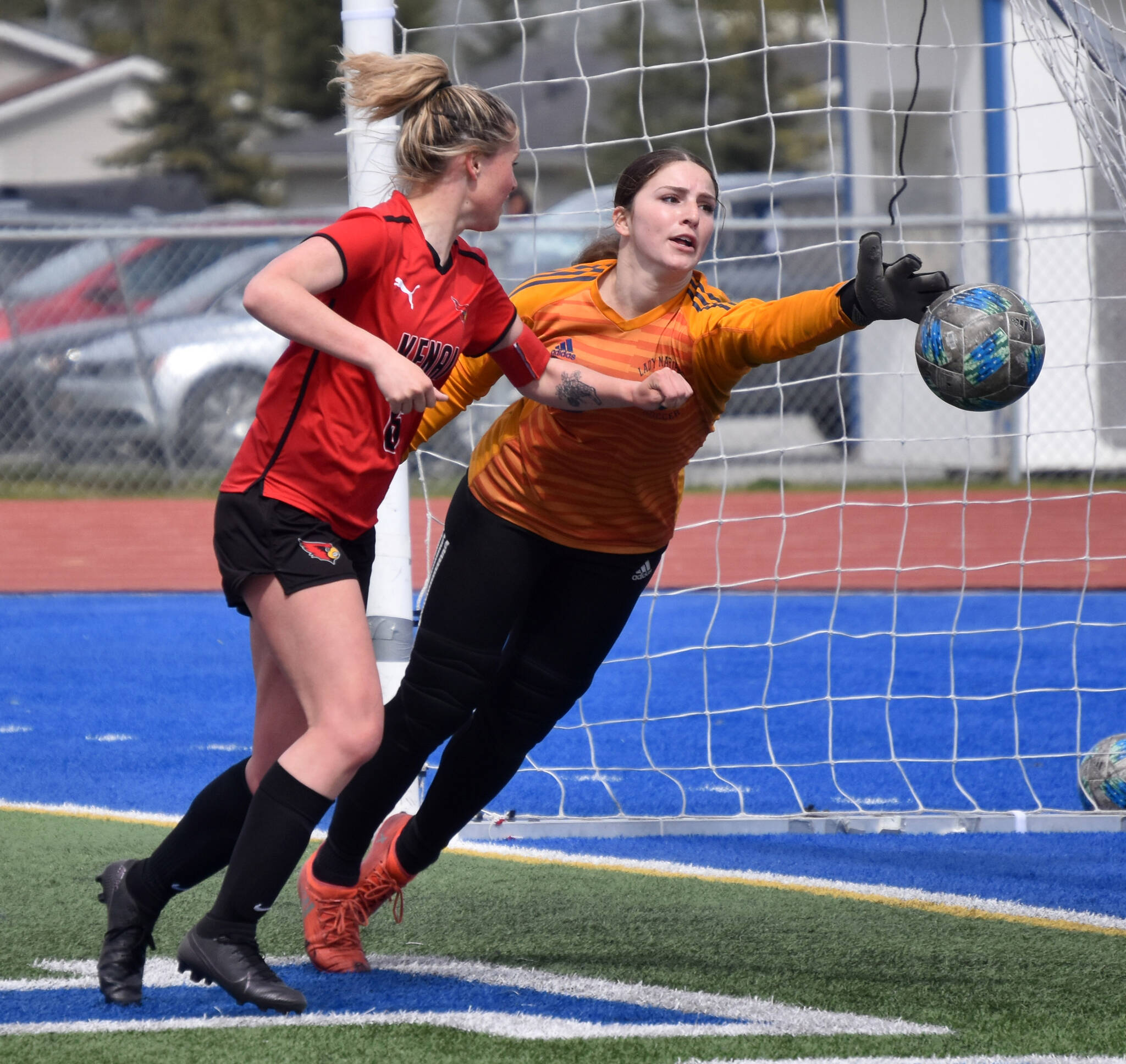 Homer goalie Felicia Weisser pushes a shot wide in front of Kenai Central’s Kori Moore on Saturday, May 20, 2023, in the championship game of the Peninsula Conference tournament at Justin Maile Field at Soldotna High School in Soldotna, Alaska. (Photo by Jeff Helminiak/Peninsula Clarion)