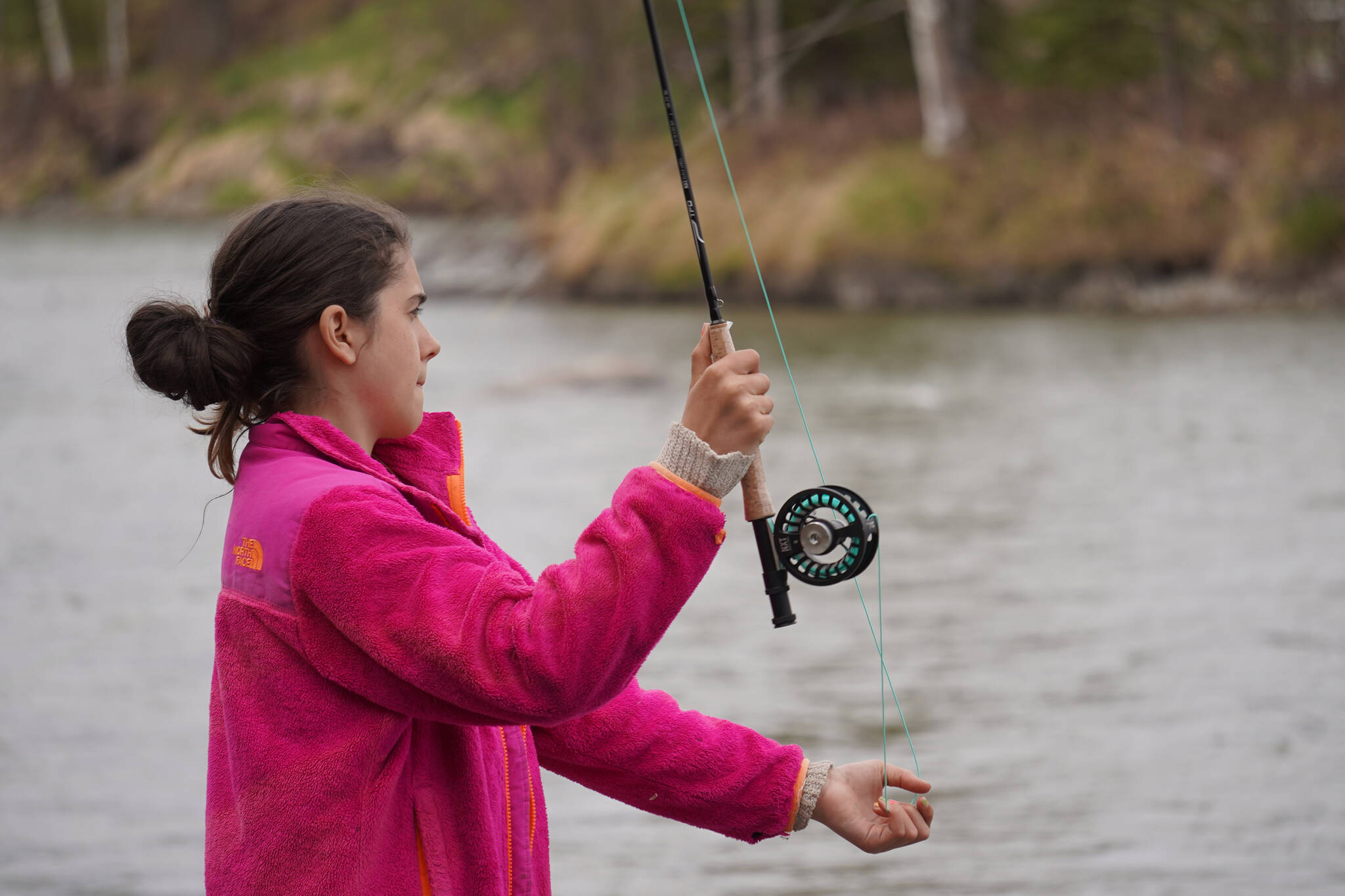 Aviana Stroh practices fly casting into the Kenai River during a kids camp put on by Trout Unlimited on Wednesday, May 24, 2023, at the Donald E. Gilman Kenai River Center in Soldotna, Alaska. (Jake Dye/Peninsula Clarion)