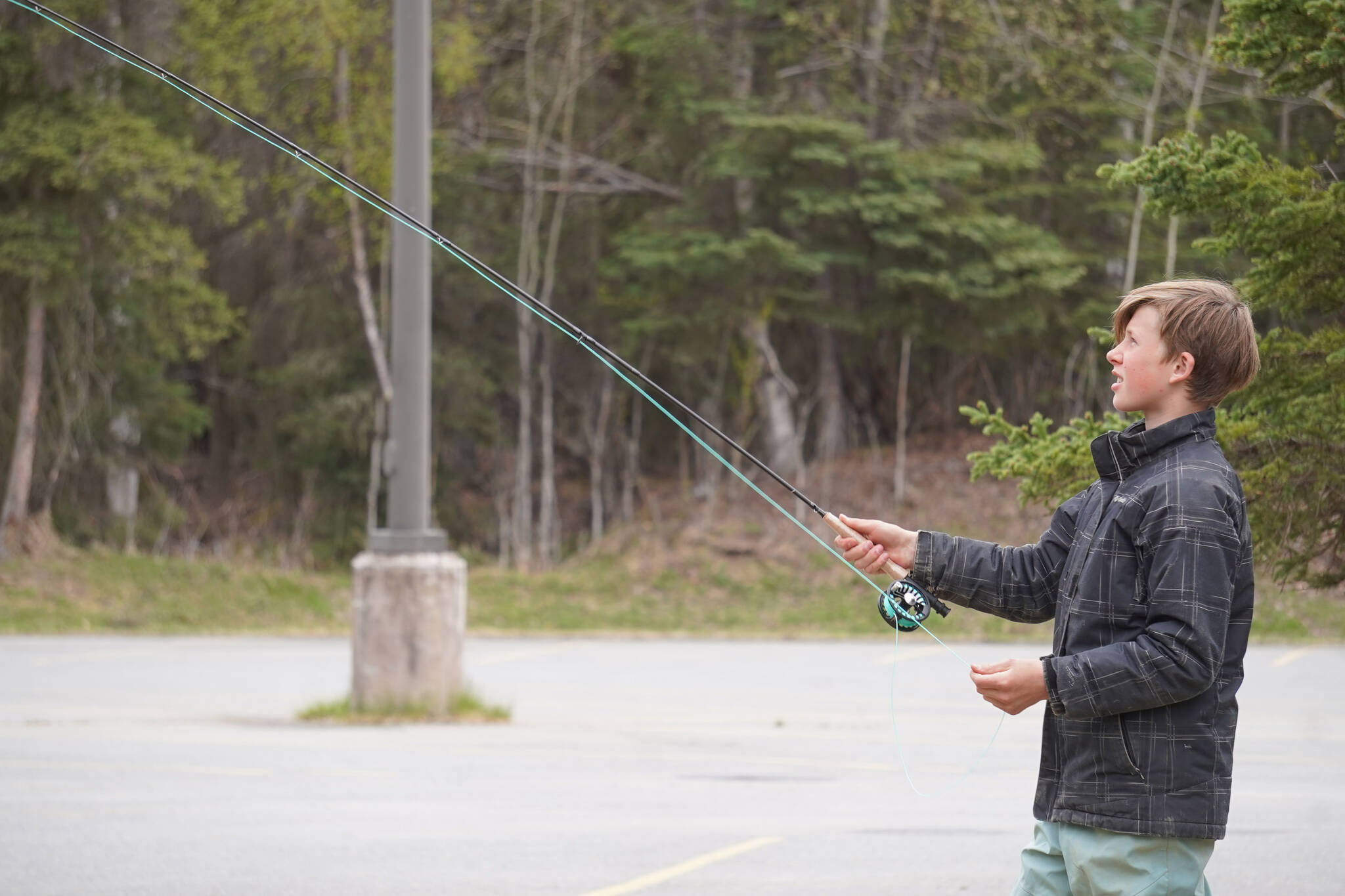 Ethan Anderson practices fly casting in the parking lot of the Donald E. Gilman Kenai River Center in Soldotna, Alaska, during a kids camp put on by Trout Unlimited on Wednesday, May 24, 2023. (Jake Dye/Peninsula Clarion)