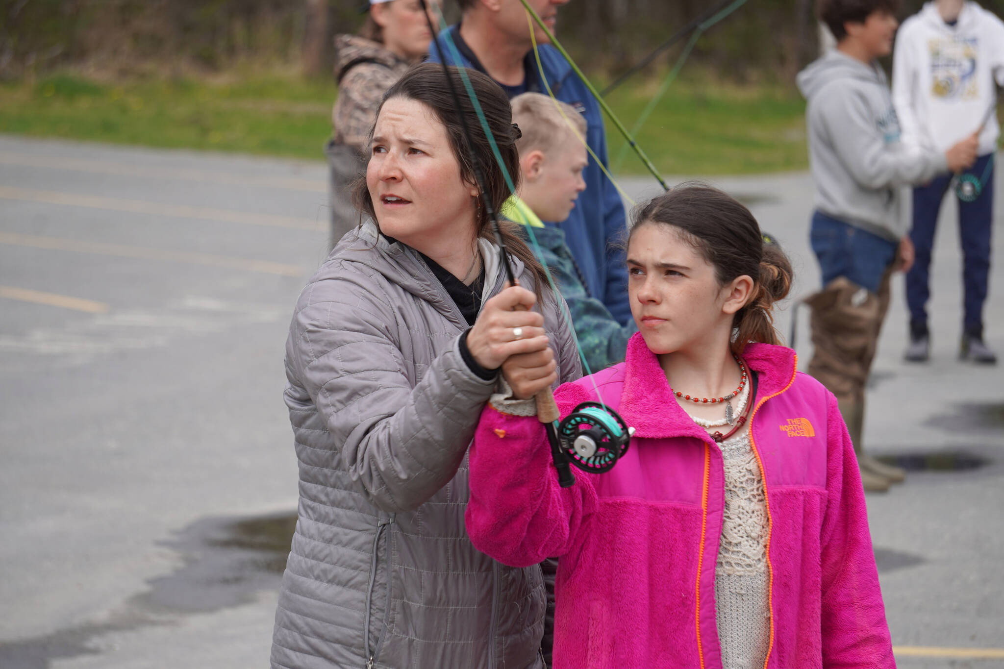 Alexa Millward helps Aviana Stroh with her fly cast during a kids camp put on by Trout Unlimited on Wednesday, May 24, 2023, at the Donald E. Gilman Kenai River Center in Soldotna, Alaska. (Jake Dye/Peninsula Clarion)