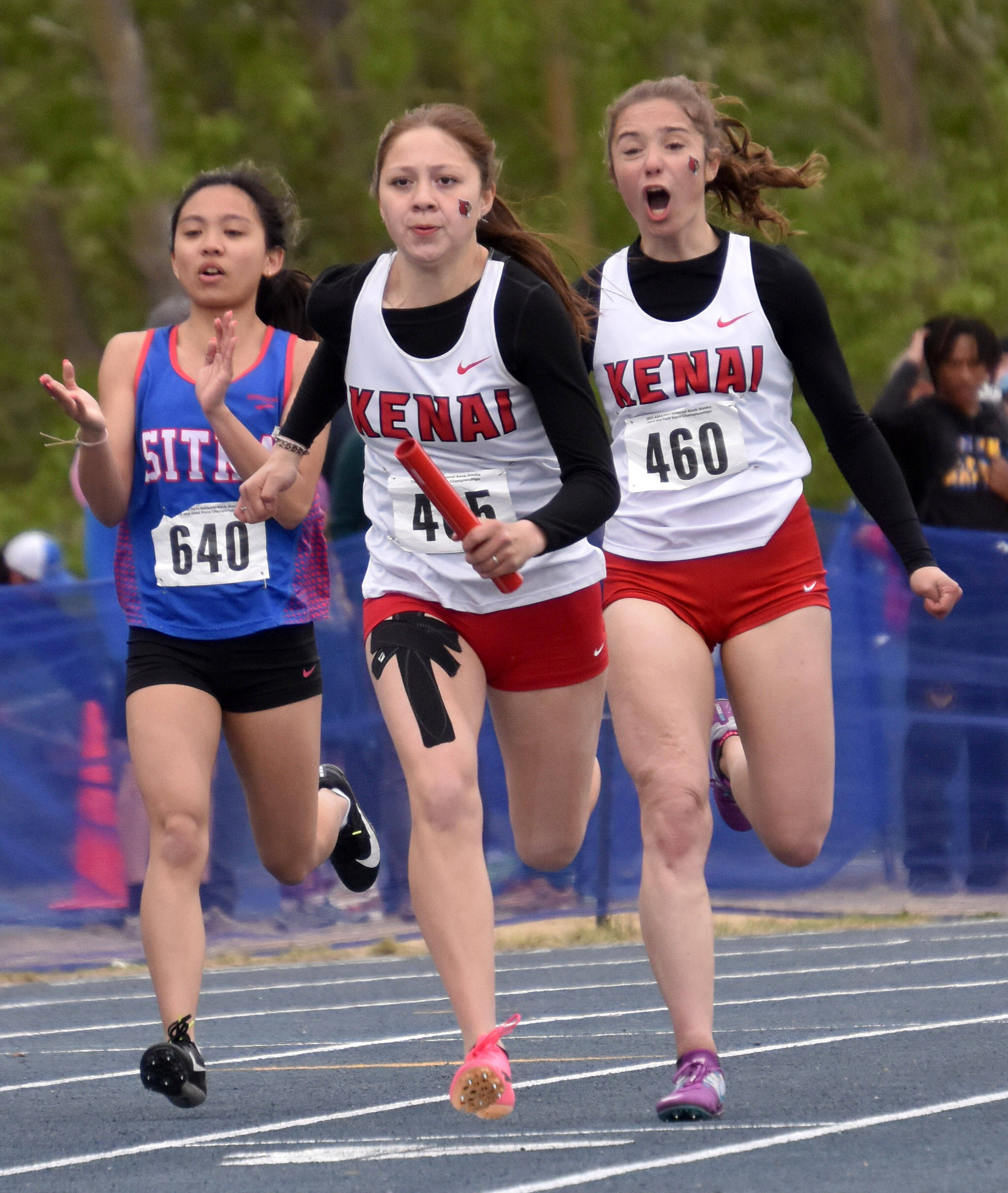 Kenai Central’s Sierra Hershberger passes the baton to Emilee Wilson in the Division II 400 relay Saturday, May 27, 2023, at the state track and field meet at Palmer High School in Palmer, Alaska. (Photo by Jeff Helminiak/Peninsula Clarion)