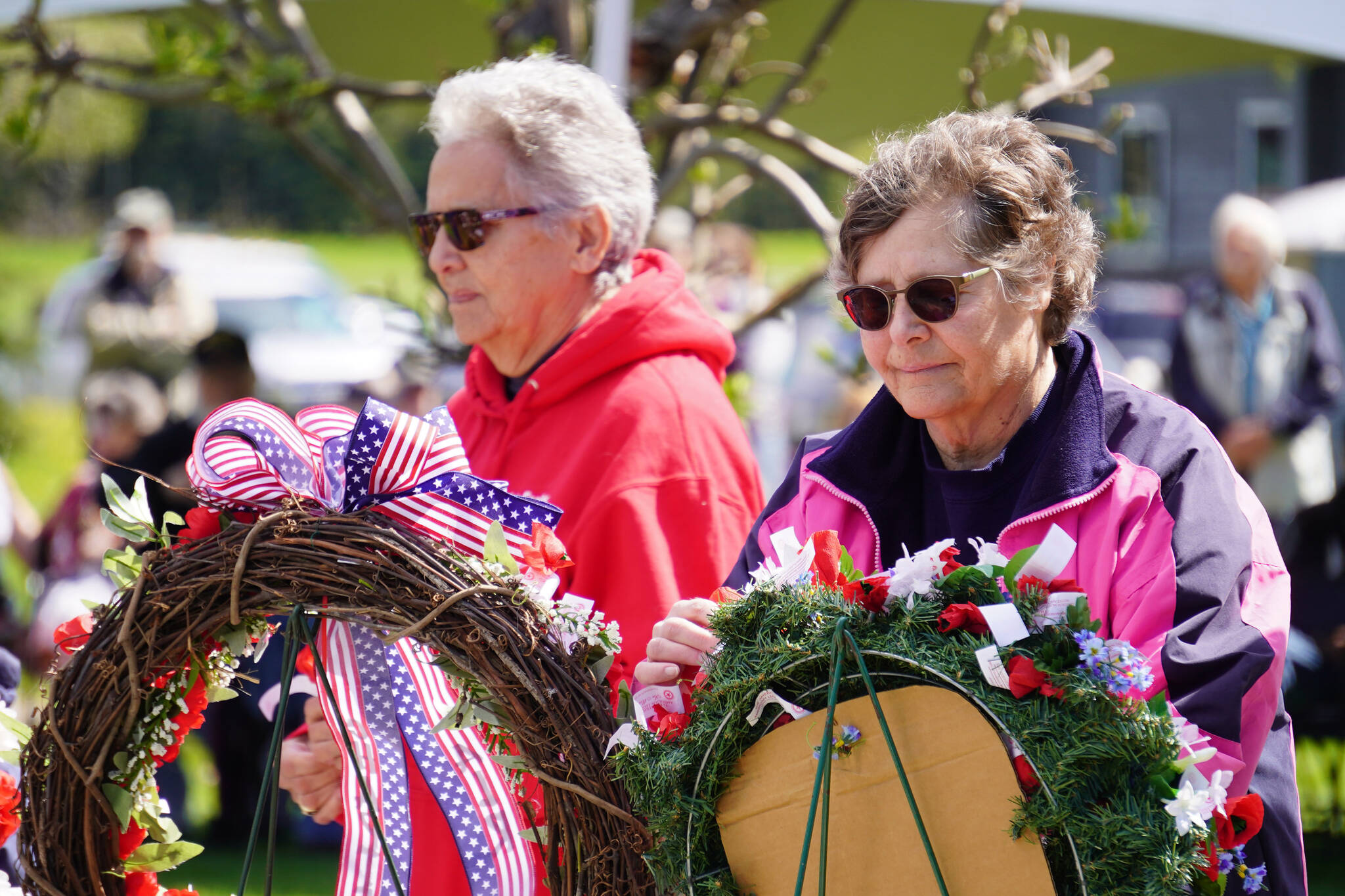 Attendees affix poppies to wreaths during a Memorial Day ceremony on Monday, May 29, 2023, at Leif Hanson Memorial Park in Kenai, Alaska. (Jake Dye/Peninsula Clarion)