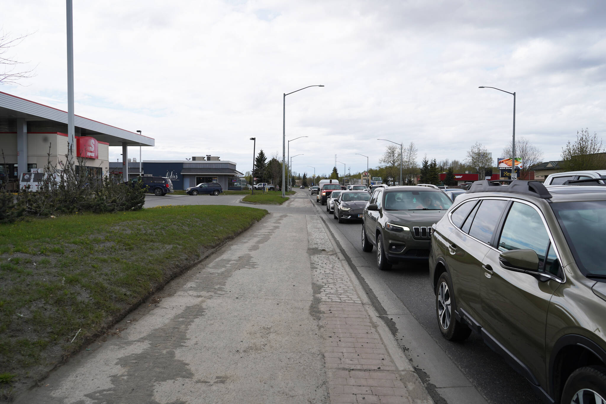 Cars line up along the Sterling Highway in Soldotna, Alaska, on Monday, May 22, 2023. (Jake Dye/Peninsula Clarion)