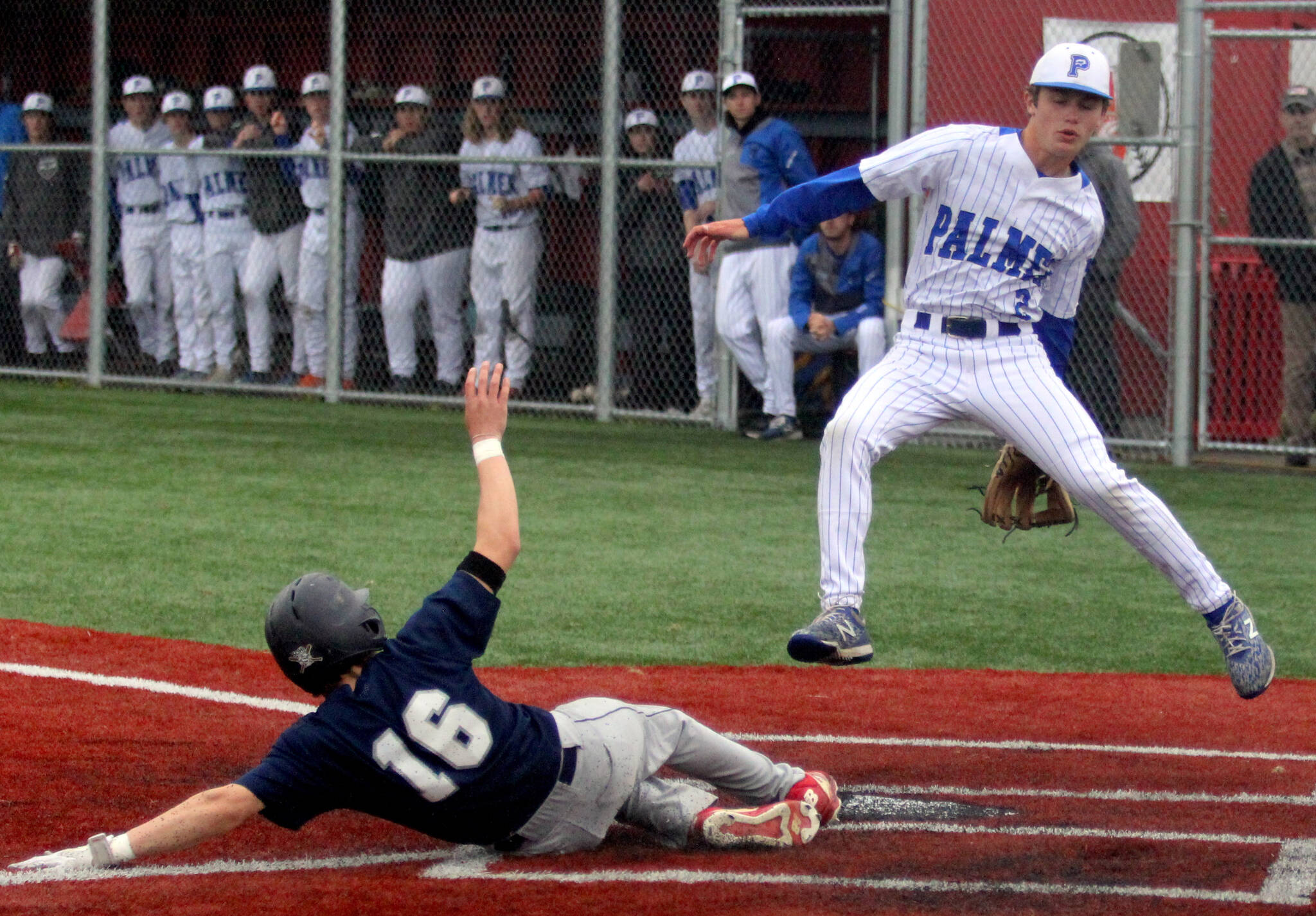 Soldotna’s Easton Hawkins slides into home underneath Palmer pitcher Reed Craner during SoHi’s six-run first inning of its Division II state quarterfinal game against the Moose Thursday, June 1, 2023, at Wasilla High School. (Jeremiah Bartz/Frontiersman)