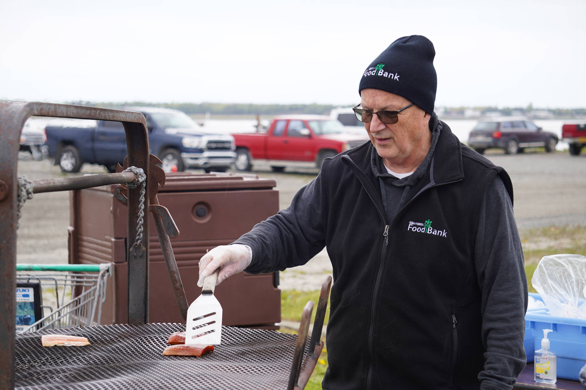 Kenai Peninsula Food Bank Executive Director Greg Meyer grills salmon at Return of the Reds on Saturday, June 3, 2023, at the Kenai City Dock in Kenai, Alaska. (Jake Dye/Peninsula Clarion)
