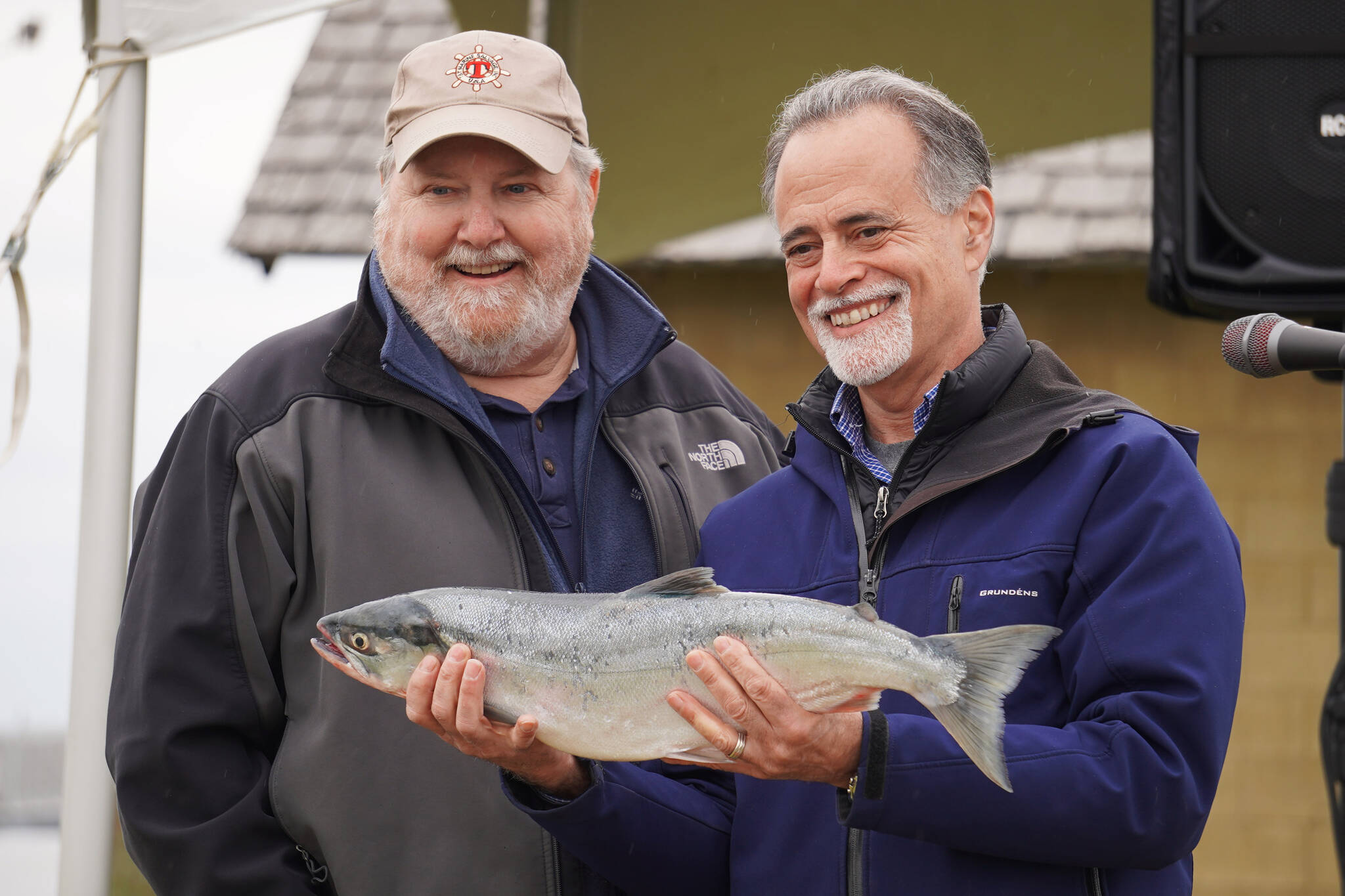 Auction winner Jim Butler and auctioneer Peter Micciche stand together with the first sockeye of the season, sold for $58 a pound at Return of the Reds on Saturday, June 3, 2023, at the Kenai City Dock in Kenai, Alaska. (Jake Dye/Peninsula Clarion)