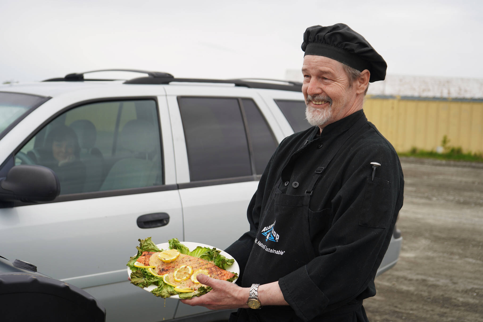 Chef Lastan Williams, of The Catch, stands with a salmon dish prepared for the Best Salmon Recipe competition at Return of the Reds on Saturday, June 3, 2023, at the Kenai City Dock in Kenai, Alaska. (Jake Dye/Peninsula Clarion)