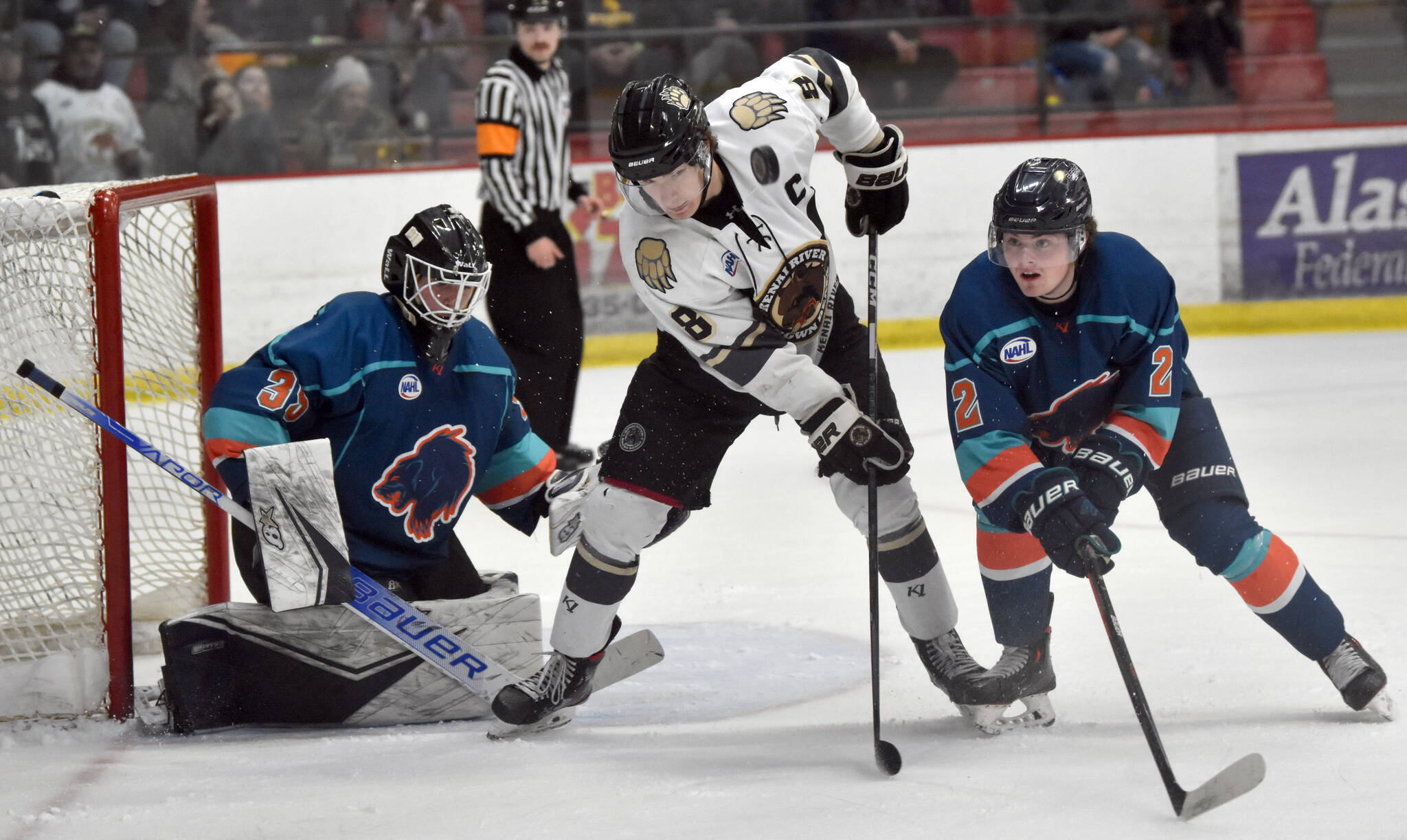 Kenai River Brown Bears forward Noah Holt battles Anchorage Wolverines defenseman Trent Powell in front of Wolverines goalie Eino Rissanen on Saturday, Nov. 19, 2022, at the Soldotna Regional Sports Complex in Soldotna, Alaska. Powell was born and raised in Soldotna. (Photo by Jeff Helminiak/Peninsula Clarion)