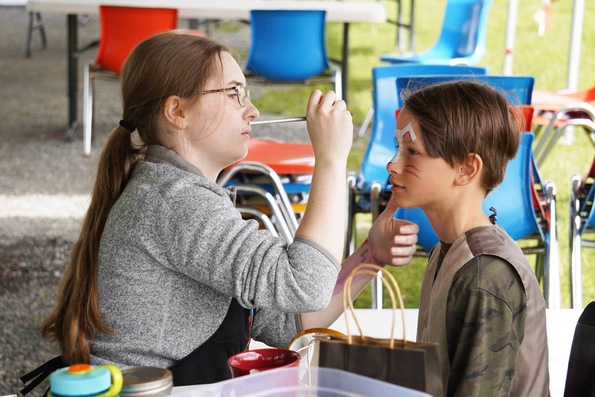 Children receive free face-painting during the Kenai River Festival on Friday, June 9, 2023, at Soldotna Creek Park in Soldotna, Alaska. (Jake Dye/Peninsula Clarion)