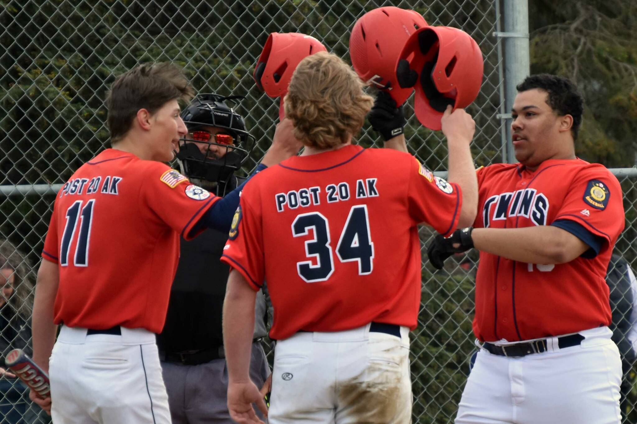Atticus Gibson (right) of the American Legion Twins is congratulated on a three-run home run by Braden Smith and Charlie Chamberlain on Sunday, June 11, 2023, at the Soldotna Little League fields in Soldotna, Alaska. (Photo by Jeff Helminiak/Peninsula Clarion)