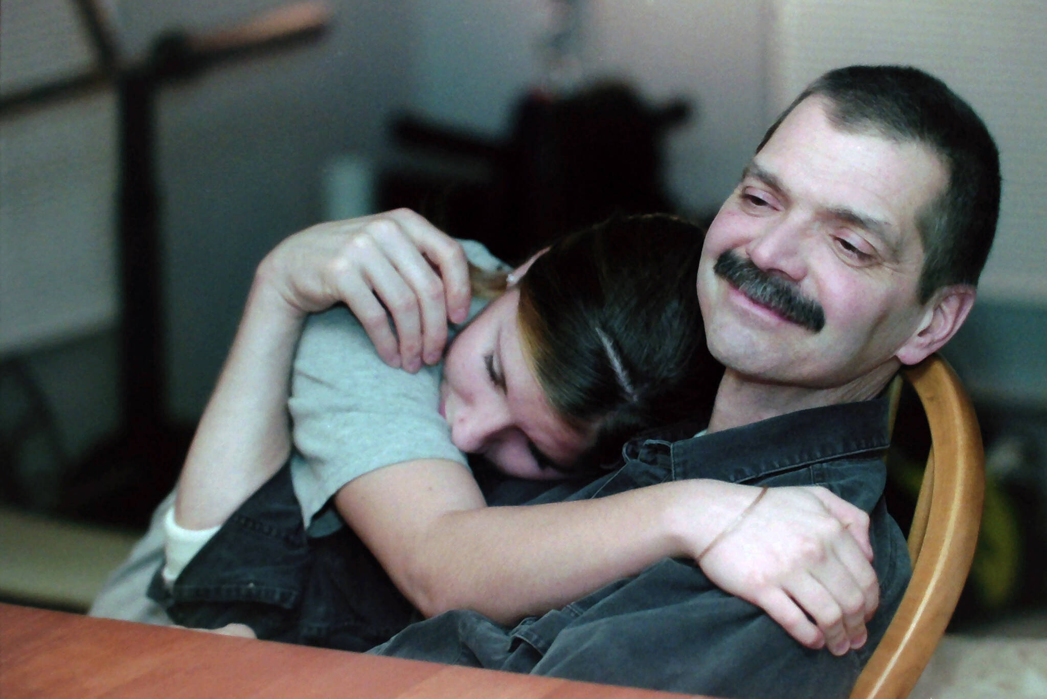 Robert Summer, right, receives a hug from his daughter Rebekah after a family dinner in November 2004. (M. Scott Moon/Peninsula Clarion file)