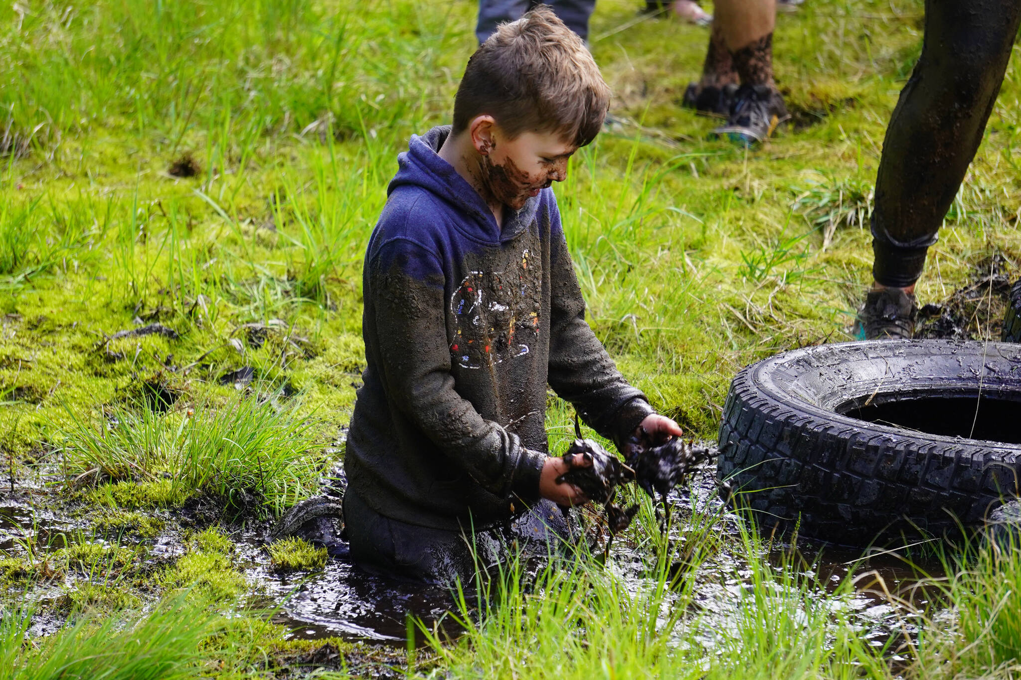 A contestant sits in the mud during the KDLL Mud Run at Tsalteshi Trails in Soldotna, Alaska, on Friday, June 16, 2023. (Jake Dye/Peninsula Clarion)