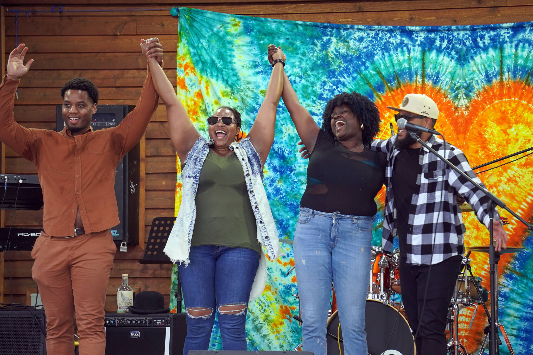 The members of Wasabi Black stand and bow at the end of their set during the Soldotna Music Series at Soldotna Creek Park in Soldotna, Alaska, on Wednesday, June 21, 2023. (Jake Dye/Peninsula Clarion)