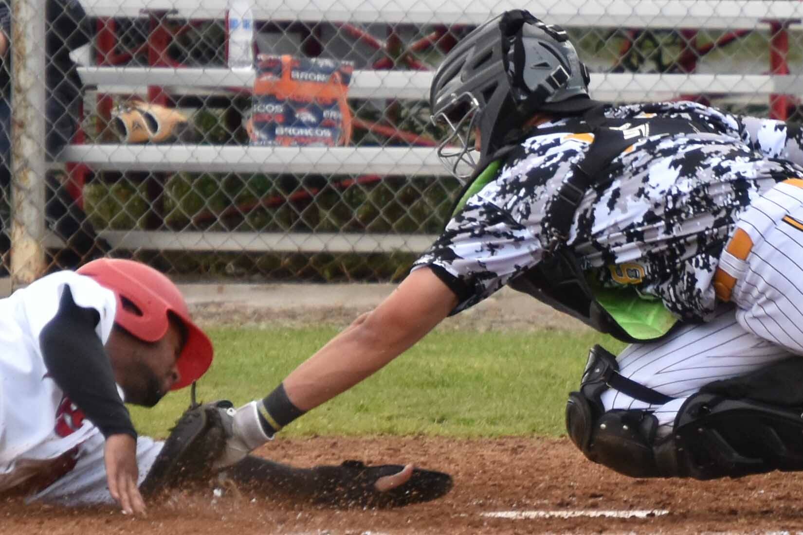 Peninsula Oilers' Drewbie Pinkston scores on a sacrifice fly past Anchorage Bucs catcher Trenton Burkhalter to tie the game at 4 in the eighth Friday, June 23, 2023, at Coral Seymour Memorial Park in Kenai, Alaska. (Photo by Jeff Helminiak/Peninsula Clarion)
