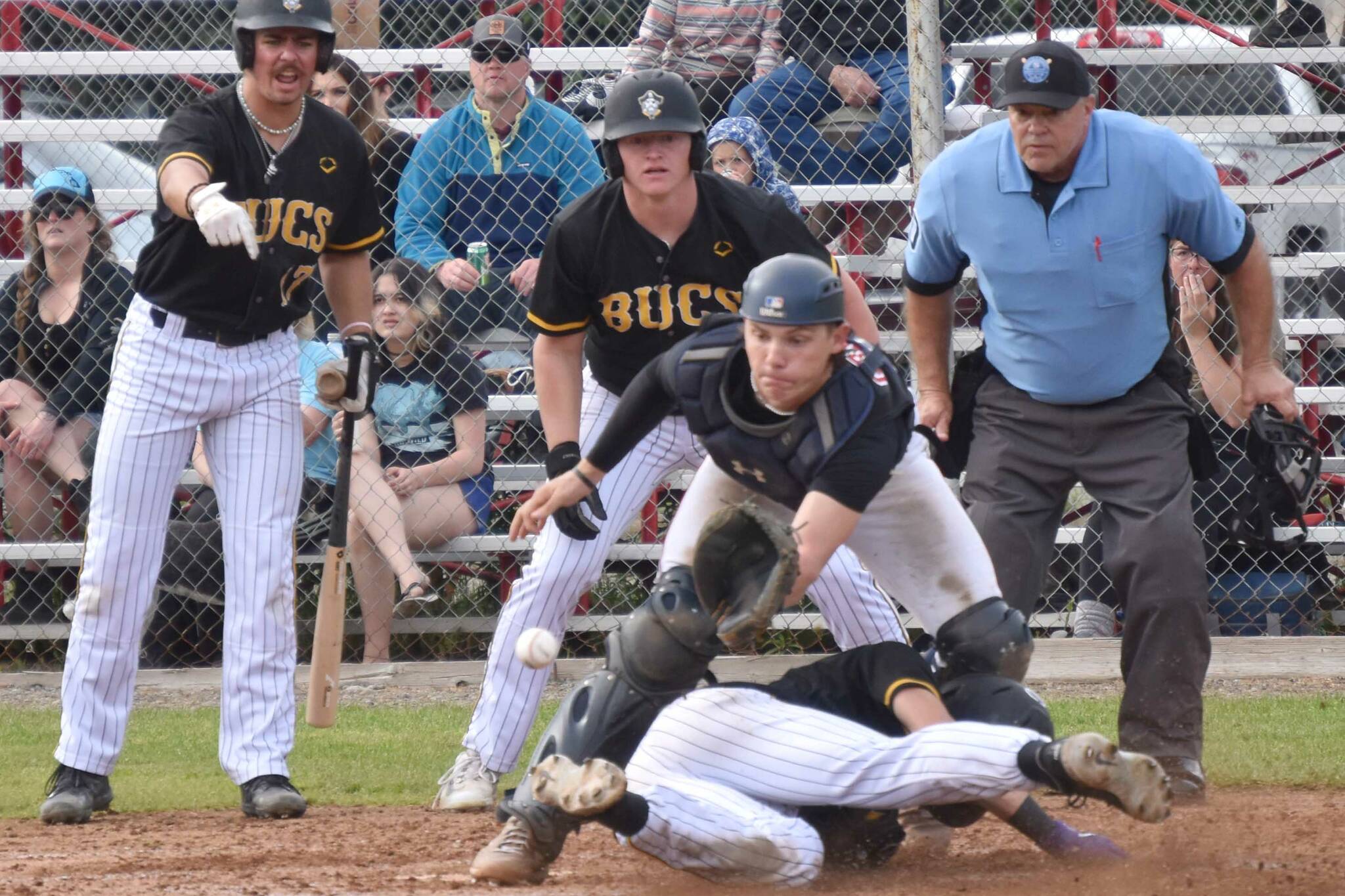 Anchorages Bucs' Curtis Hebert beats the tag of Peninsula Oilers catcher Ben Griffin on Saturday, June 24, 2023, at Coral Seymour Memorial Park in Kenai, Alaska. (Photo by Jeff Helminiak/Peninsula Clarion)