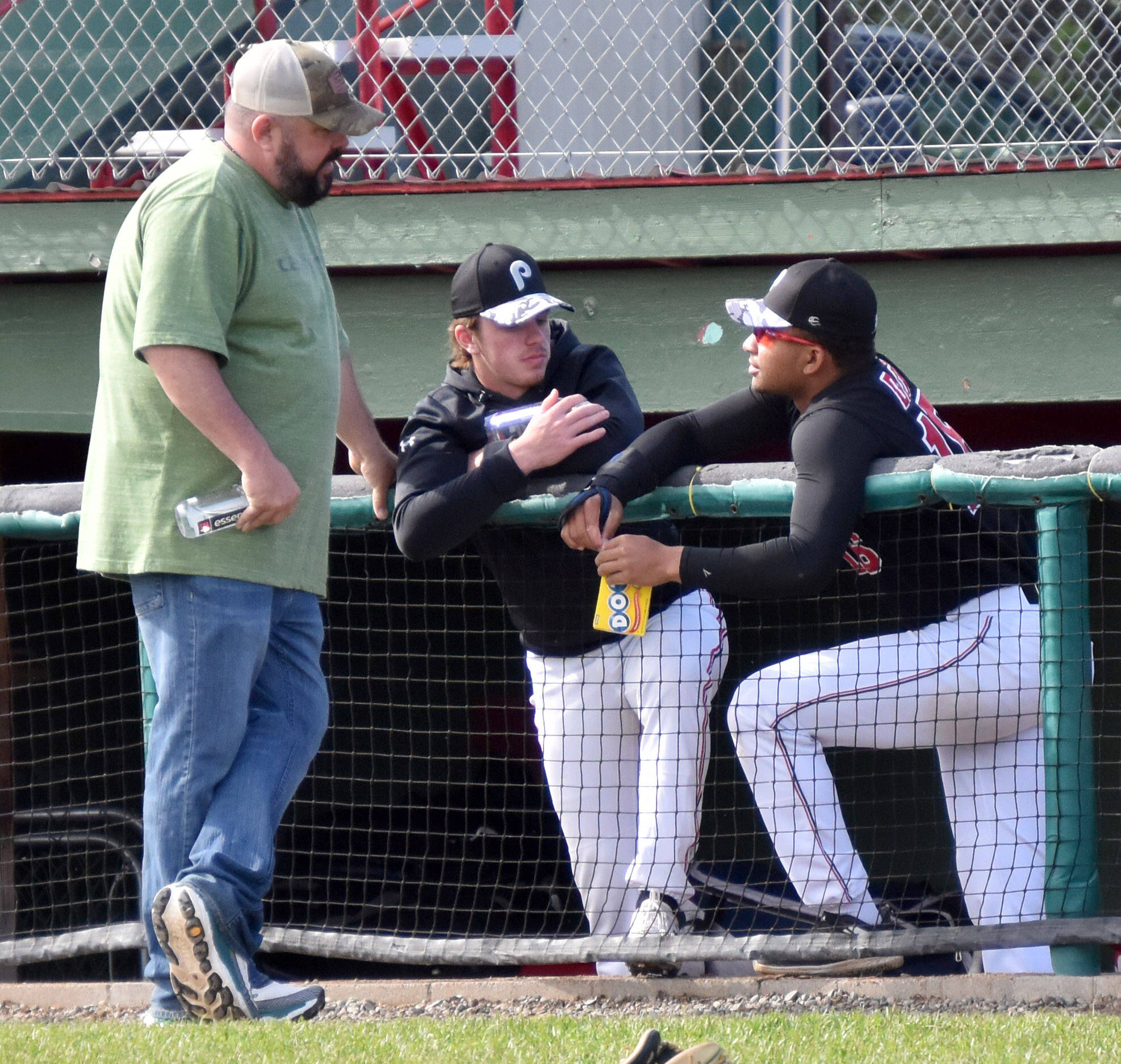 Oilers general manager Derek Foote talks with a pair of players Saturday, June 24, 2023, before a game against the Anchorage Bucs at Coral Seymour Memorial Park in Kenai, Alaska. (Photo by Jeff Helminiak/Peninsula Clarion)