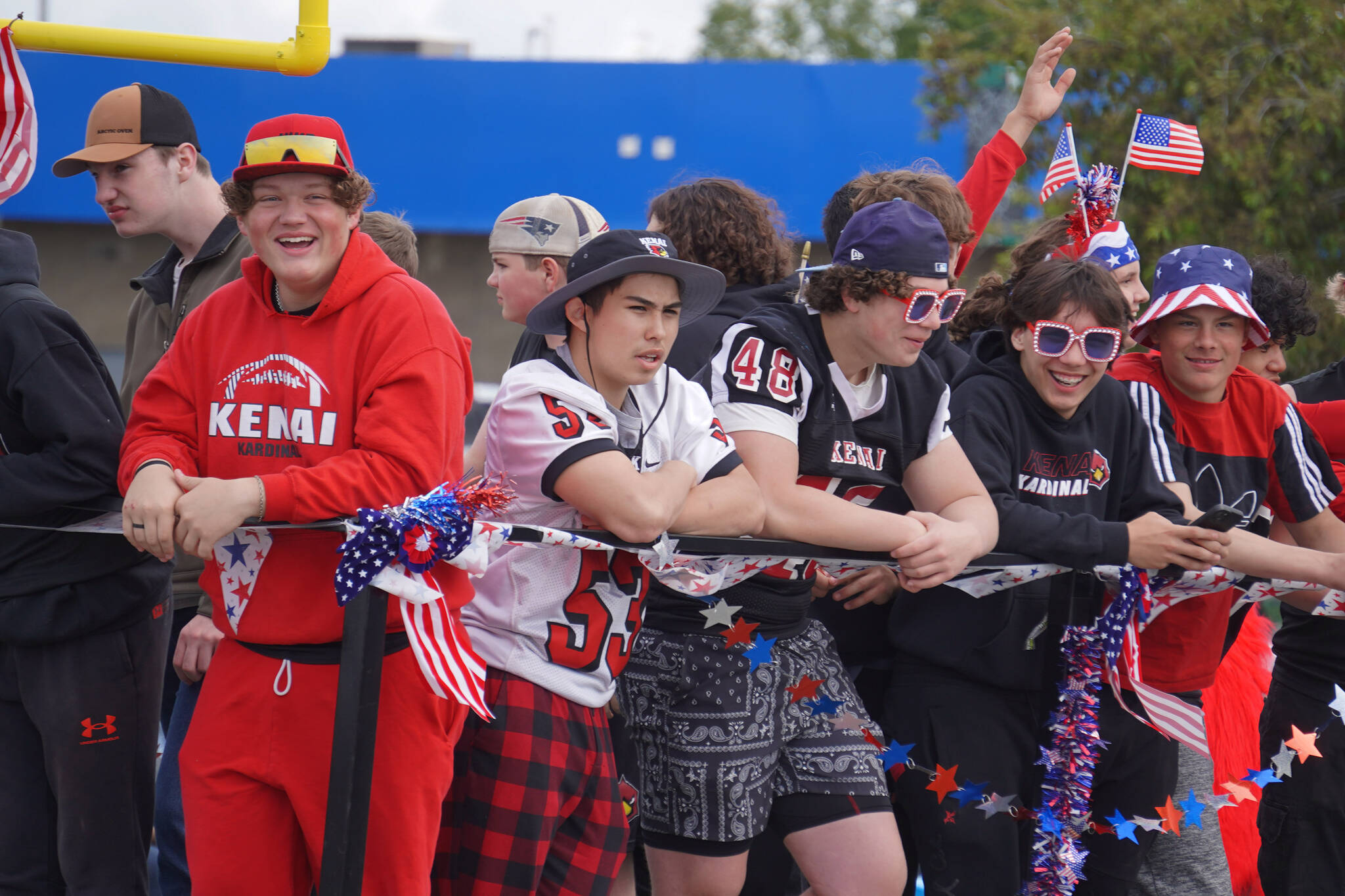 The Kenai Central High School football team smiles as the Fourth of July Parade moves down the Kenai Spur Highway in Kenai, Alaska on Tuesday, July 4, 2023. (Jake Dye/Peninsula Clarion)