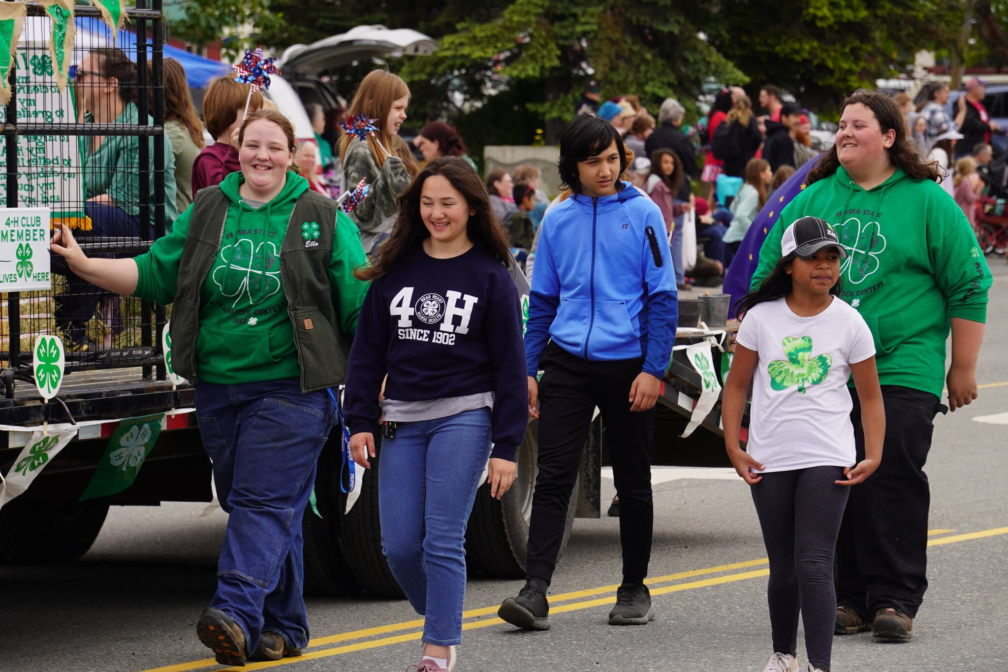 Members of the Kenai Peninsula District 4-H smile and wave as the Fourth of July Parade moves down the Kenai Spur Highway in Kenai, Alaska on Tuesday, July 4, 2023. (Jake Dye/Peninsula Clarion)