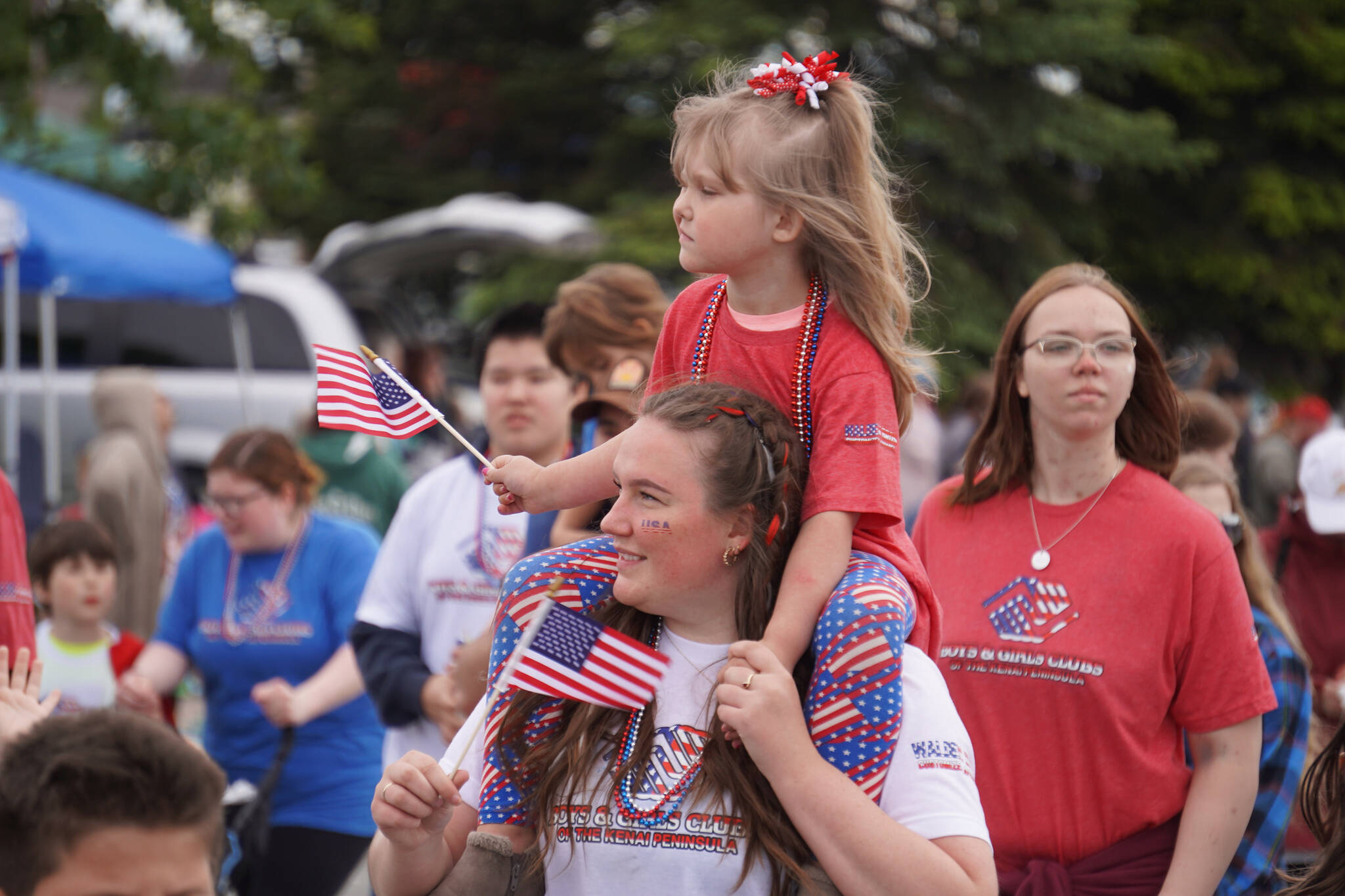 The Boys & Girls Clubs of the Kenai Peninsula smile and wave as the Fourth of July Parade moves down the Kenai Spur Highway in Kenai, Alaska on Tuesday, July 4, 2023. (Jake Dye/Peninsula Clarion)