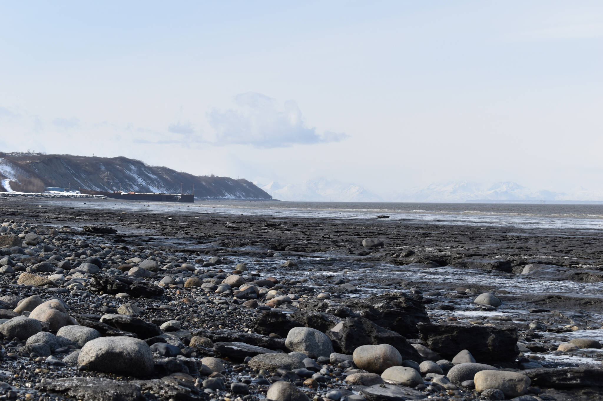 The waters of Cook Inlet lap against Nikishka Beach in Nikiski, Alaska, where several local fish sites are located, on Friday, March 24, 2023. (Jake Dye/Peninsula Clarion)