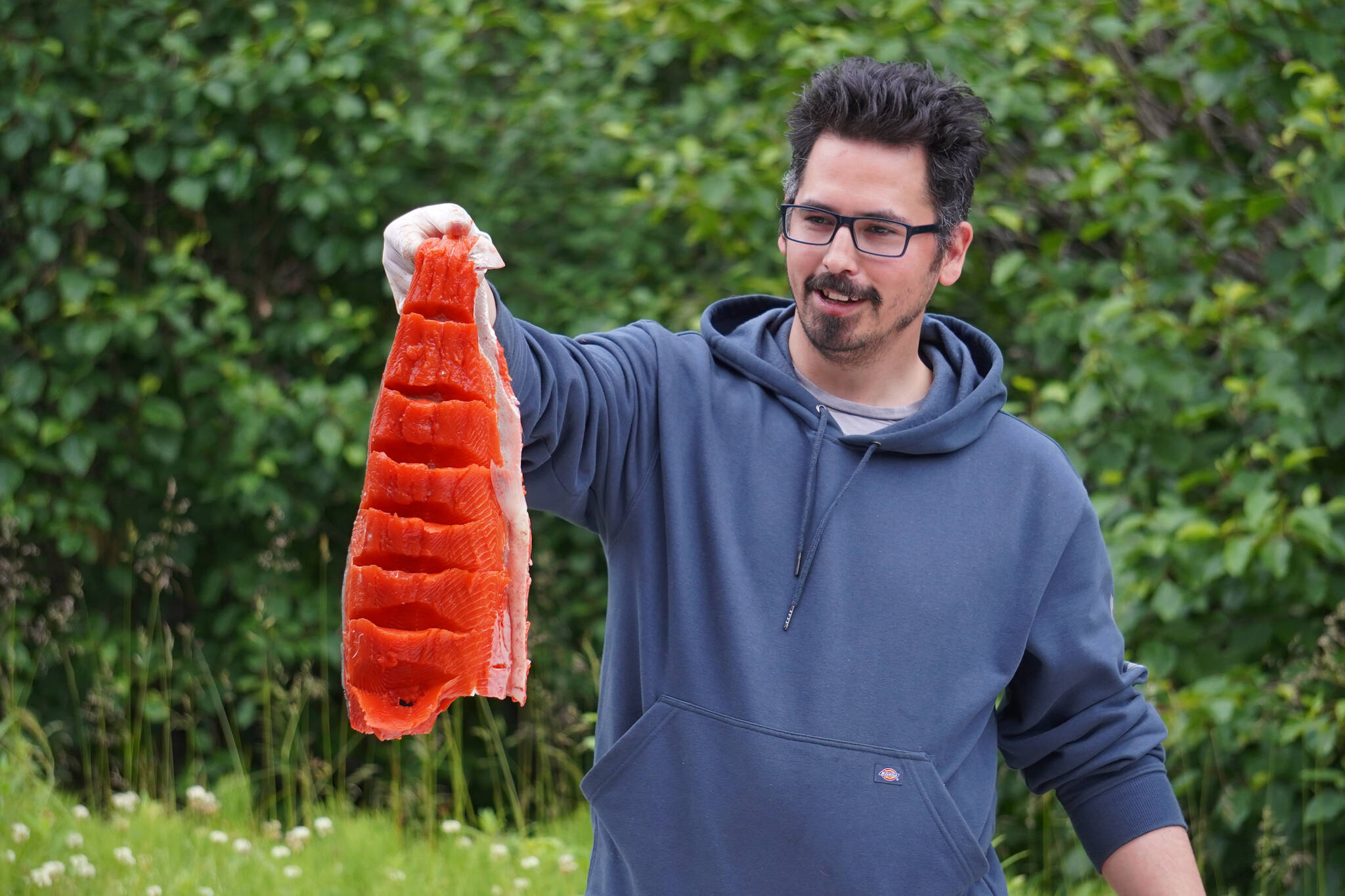 James Wardlow shows off a salmon filet ready to be hung and dried during a smoked salmon demonstration, part of Fish Week 2023, on Wednesday, July 19, 2023, at the Kenai National Wildlife Refuge Visitor Center in Soldotna, Alaska. (Jake Dye/Peninsula Clarion)