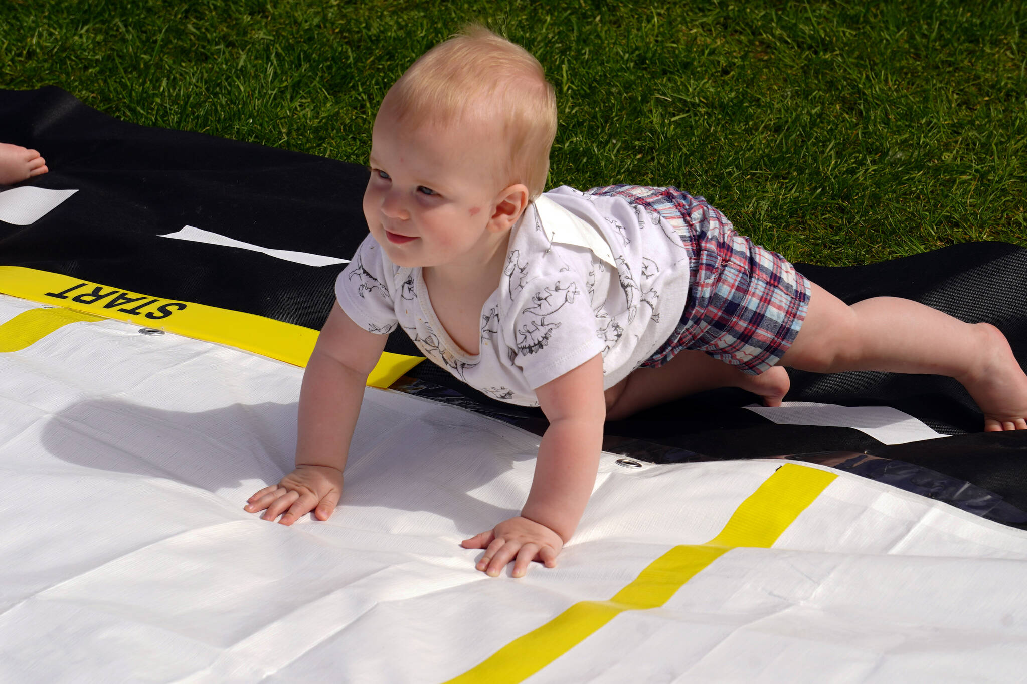 Flynn Byler, 8 months old, participates in the Diaper Derby, part of the Progress Days Fair at Soldotna Creek Park in Soldotna, Alaska, on Friday, July 21, 2023. Byler would ultimately win the race. (Jake Dye/Peninsula Clarion)