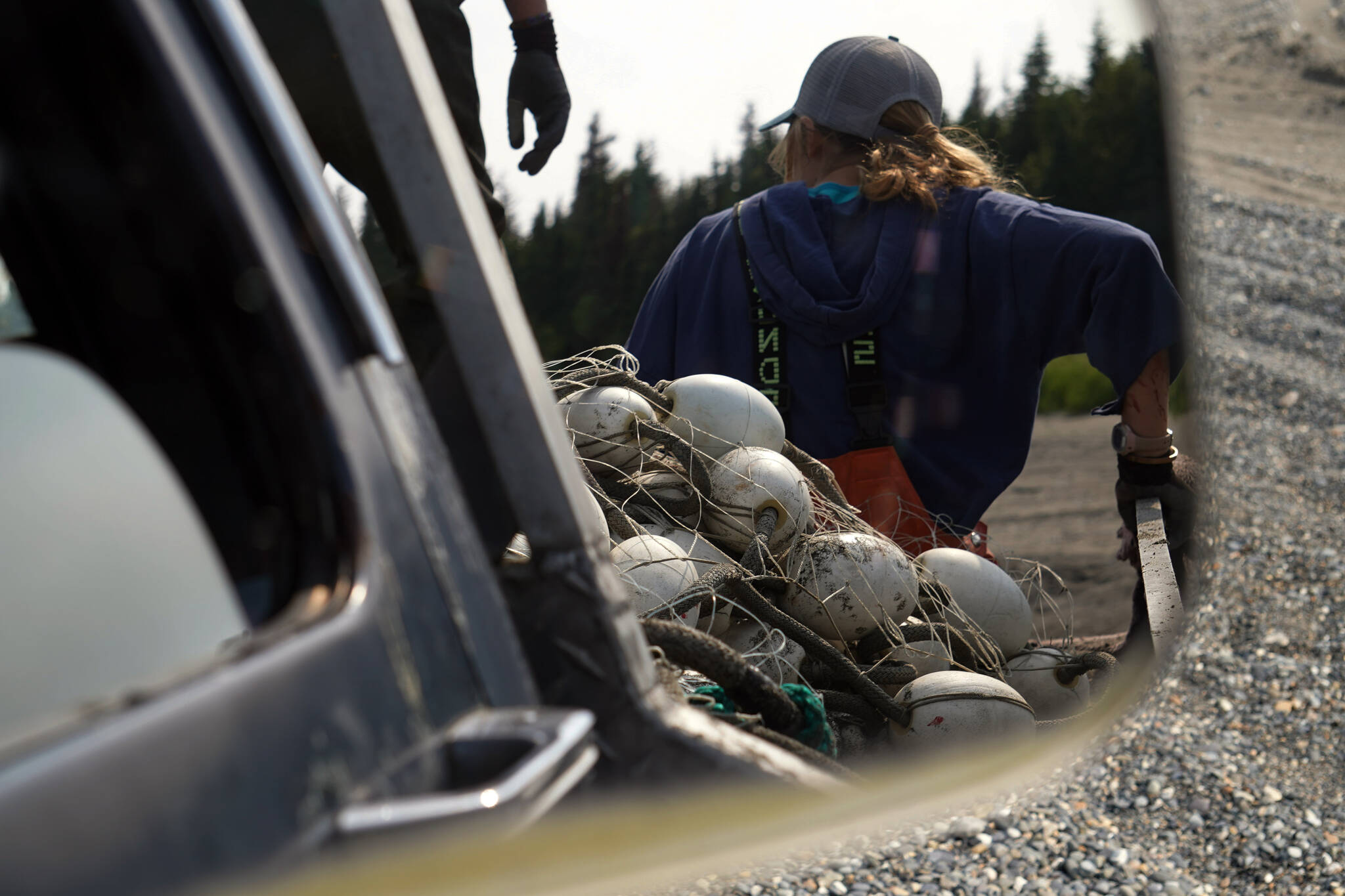 Crew ride in the back of a pickup truck with the nets at a test site for selective harvest setnet gear in Kenai, Alaska, on Tuesday, July 25, 2023. (Jake Dye/Peninsula Clarion)