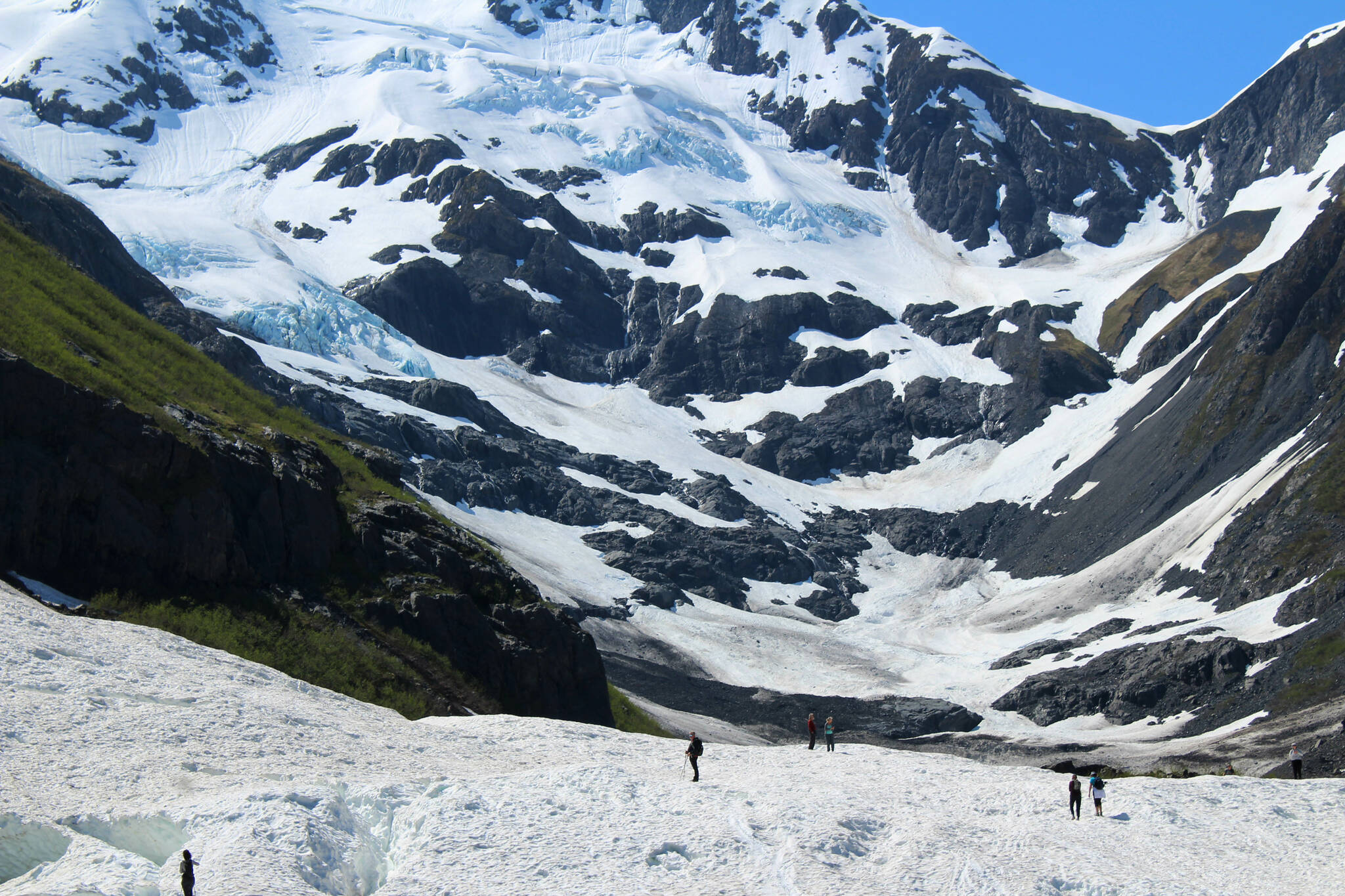Hikers walk around the base of Byron Glacier on Sunday, June 18, 2023 near Girdwood, Alaska. (Ashlyn O'Hara/Peninsula Clarion)