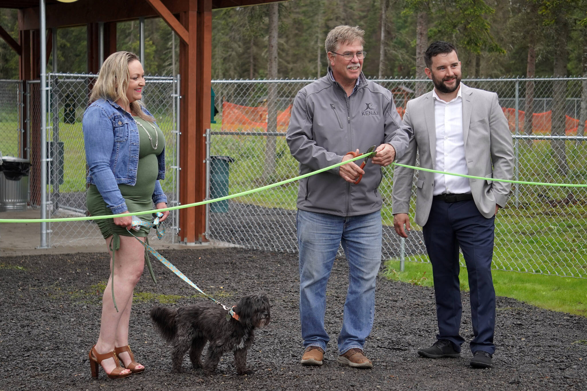Lena Wissner, Brian Gabriel, and Tyler Best cut the ribbon at a grand opening ceremony for the Kenai Bark Park in Kenai, Alaska, on Friday, July 28, 2023. (Jake Dye/Peninsula Clarion)