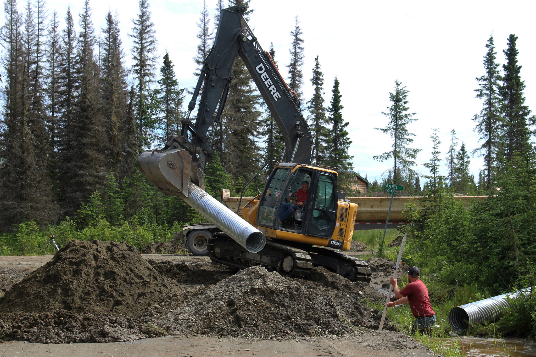 Contractors for the Kenai Peninsula Borough install a culvert at the intersection of Patrick Dr. and Bjerke St. to mitigate flooding off of Kalifornsky Beach Rd. on Friday, July 21, 2023 near Kenai, Alaska. (Ashlyn O’Hara/Peninsula Clarion)