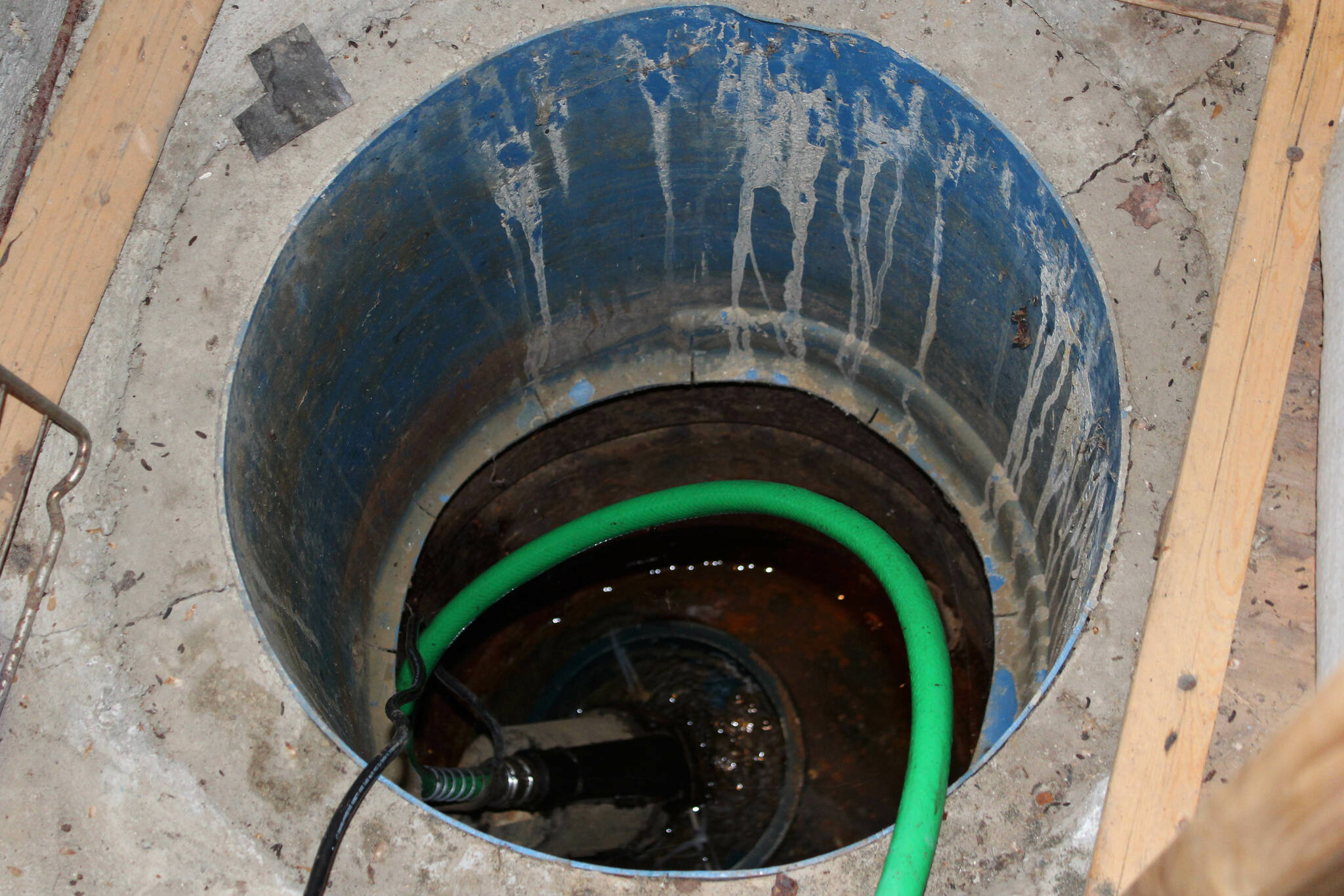 A pump sucks water out of a hole in Marcus Ashkenasy’s garage on Monday, July 24, 2023 near Kenai, Alaska. (Ashlyn O’Hara/Peninsula Clarion)