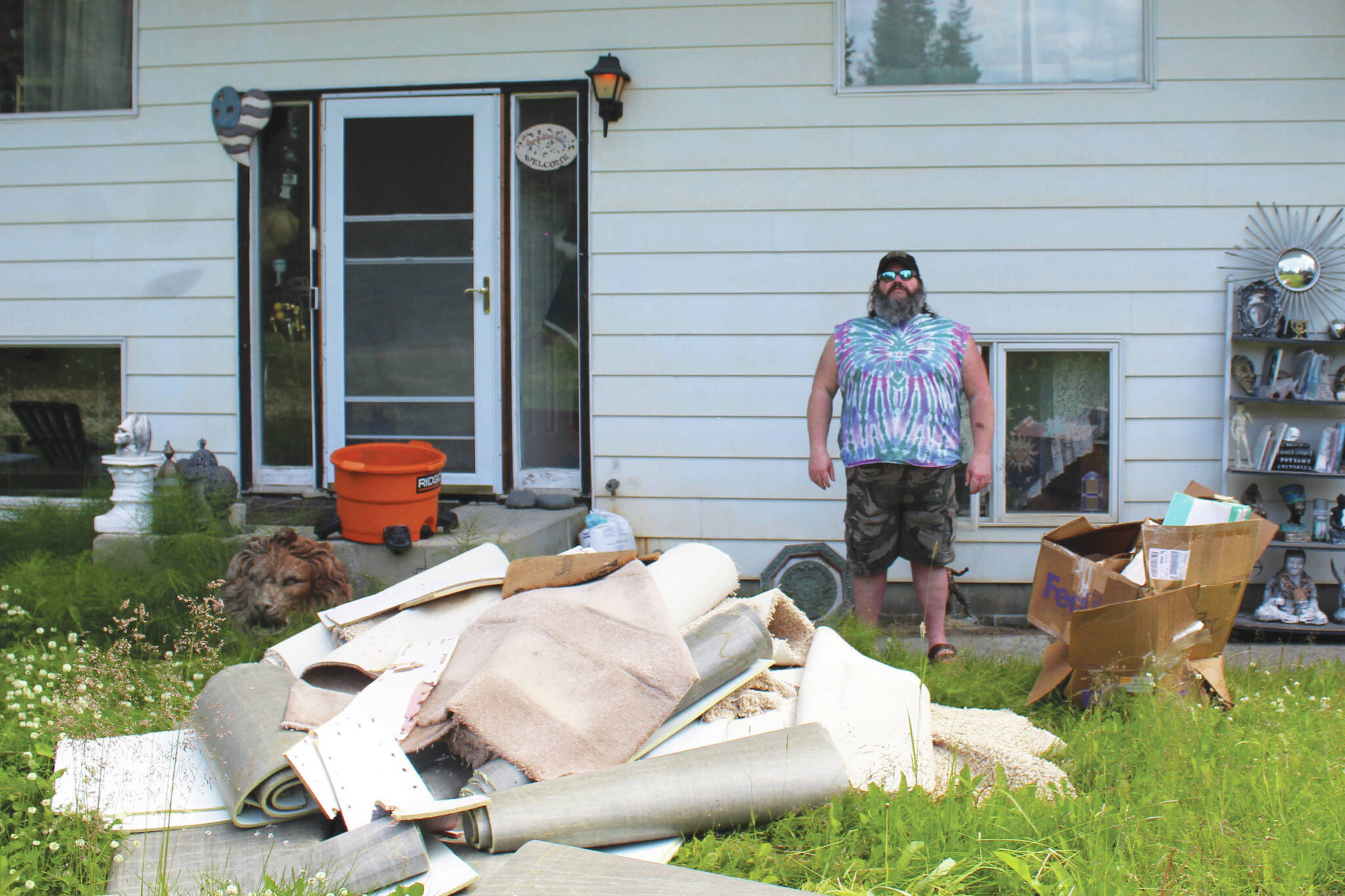 Ashlyn O’Hara/Peninsula Clarion
Marcus Ashkenasy stands near a pile of water-damaged carpet pulled from the bottom level of his house, July 24 near Kenai.