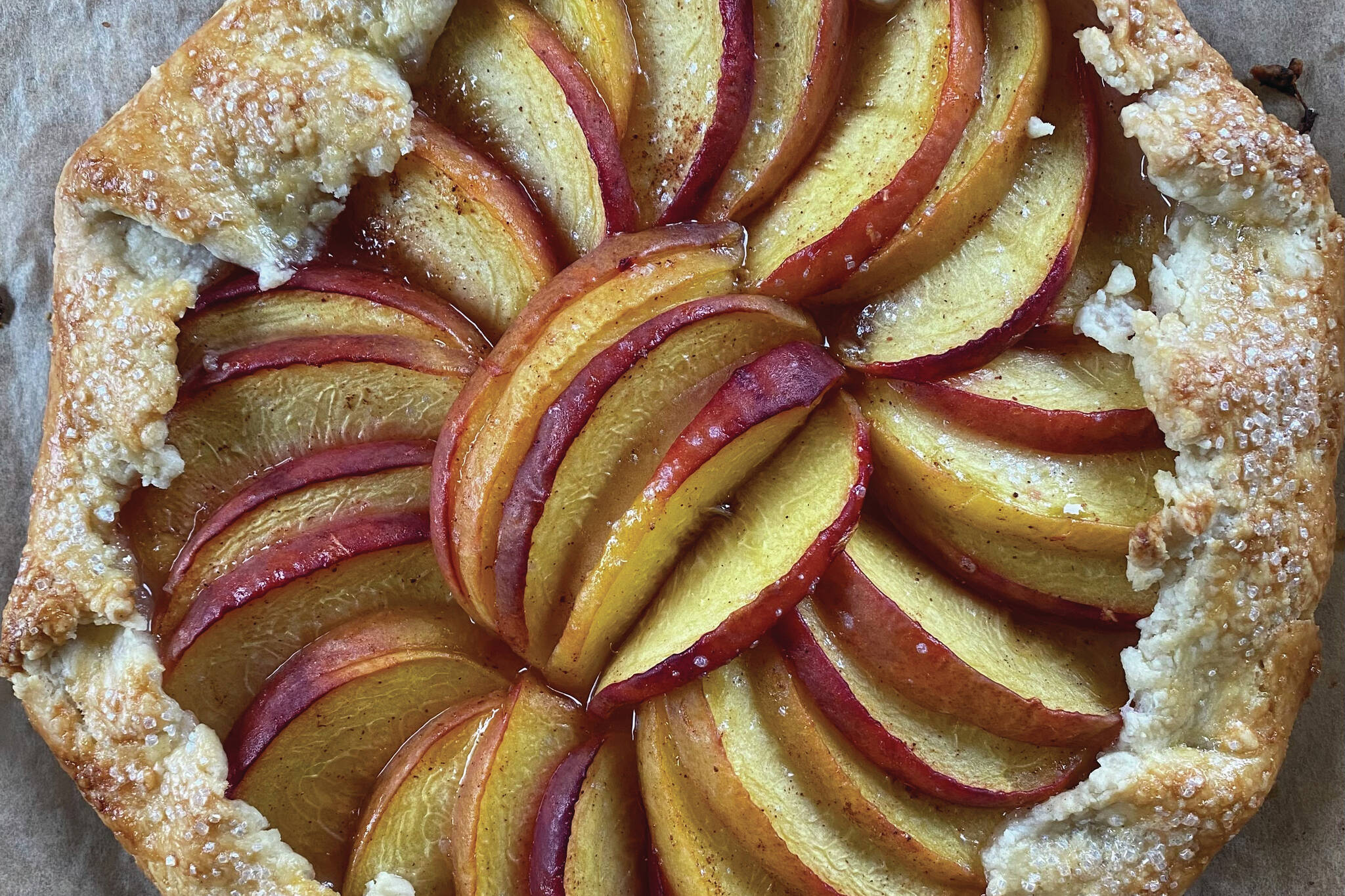 Fresh ripe peaches are wrapped in a buttery crust in this peach galette recipe. (Photo by Tressa Dale/Peninsula Clarion)