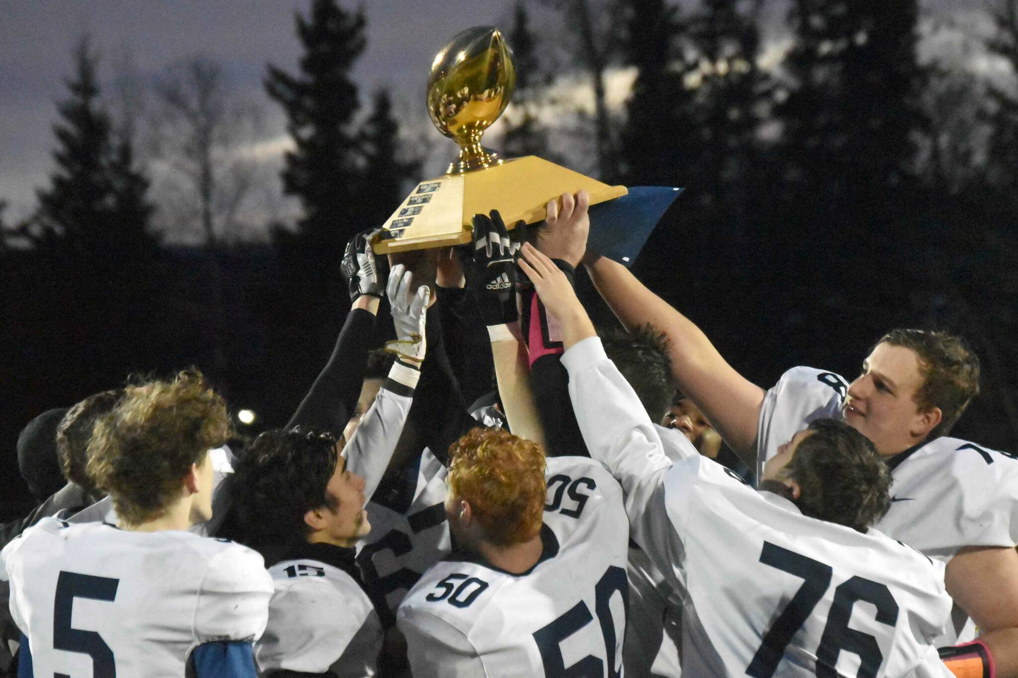 Homer hoists the Division III state championship trophy Saturday, Oct. 15, 2022, at Service High School in Anchorage, Alaska. (Photo by Jeff Helminiak/Peninsula Clarion)
