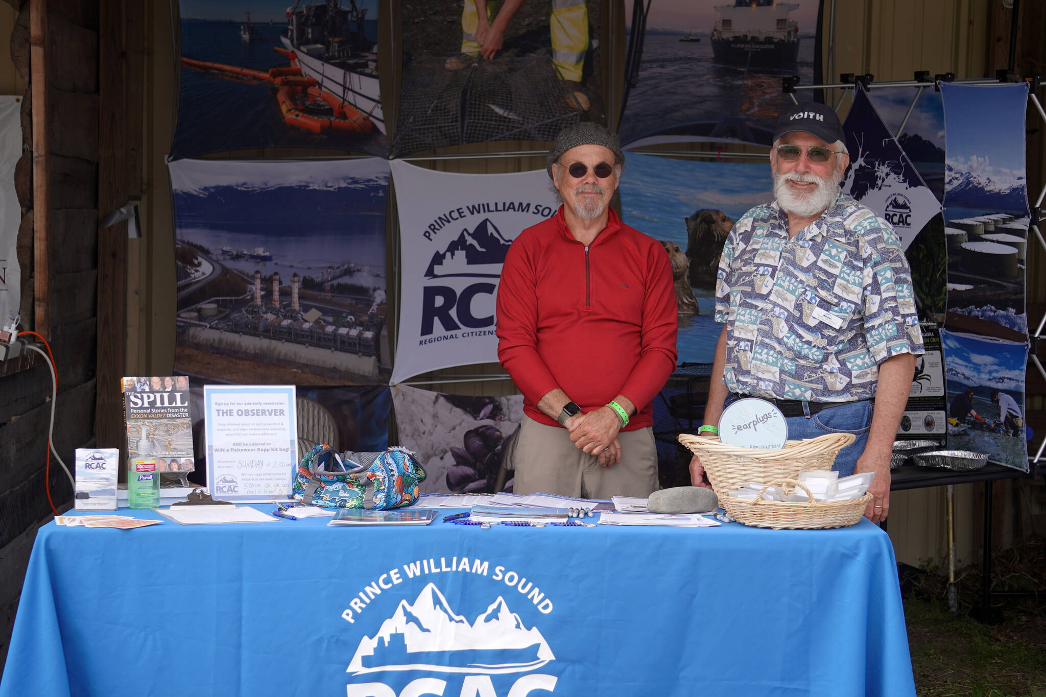 Max Mitchell and Robert Archibald man a booth for the Prince William Sound Regional Citizens’ Advisory Council at Salmonfest in Ninilchik, Alaska, on Friday, Aug. 4, 2023. (Jake Dye/Peninsula Clarion)