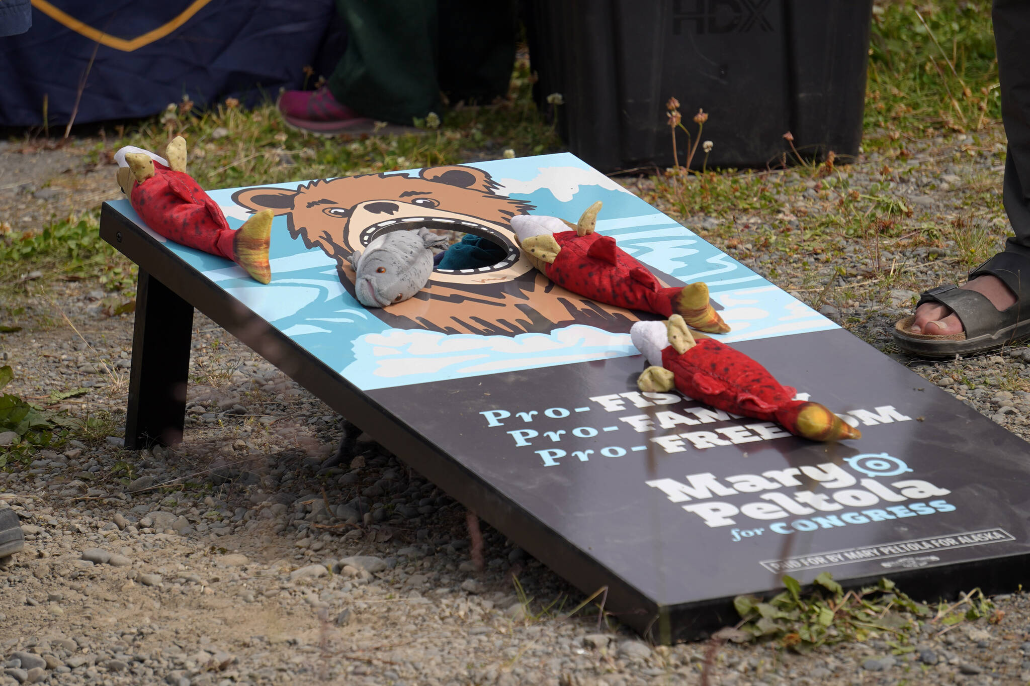 Attendees play corn hole with salmon-themed bags at Salmonfest in Ninilchik, Alaska, on Friday, Aug. 4, 2023. (Jake Dye/Peninsula Clarion)