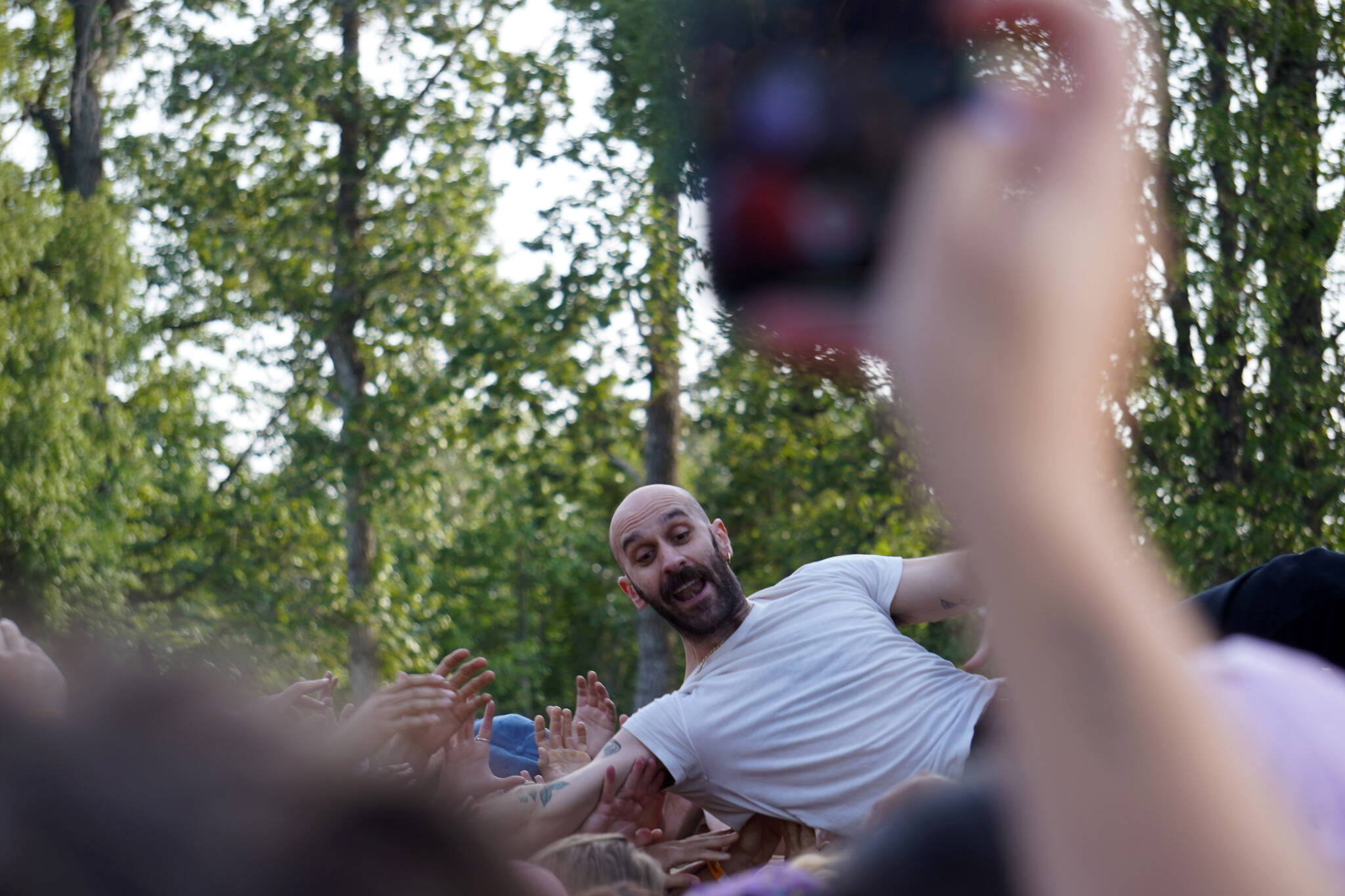 Sam Nelson crowdsurfs while performing with Medium Build on the River Stage at Salmonfest in Ninilchik, Alaska, on Friday, Aug. 4, 2023. (Jake Dye/Peninsula Clarion)