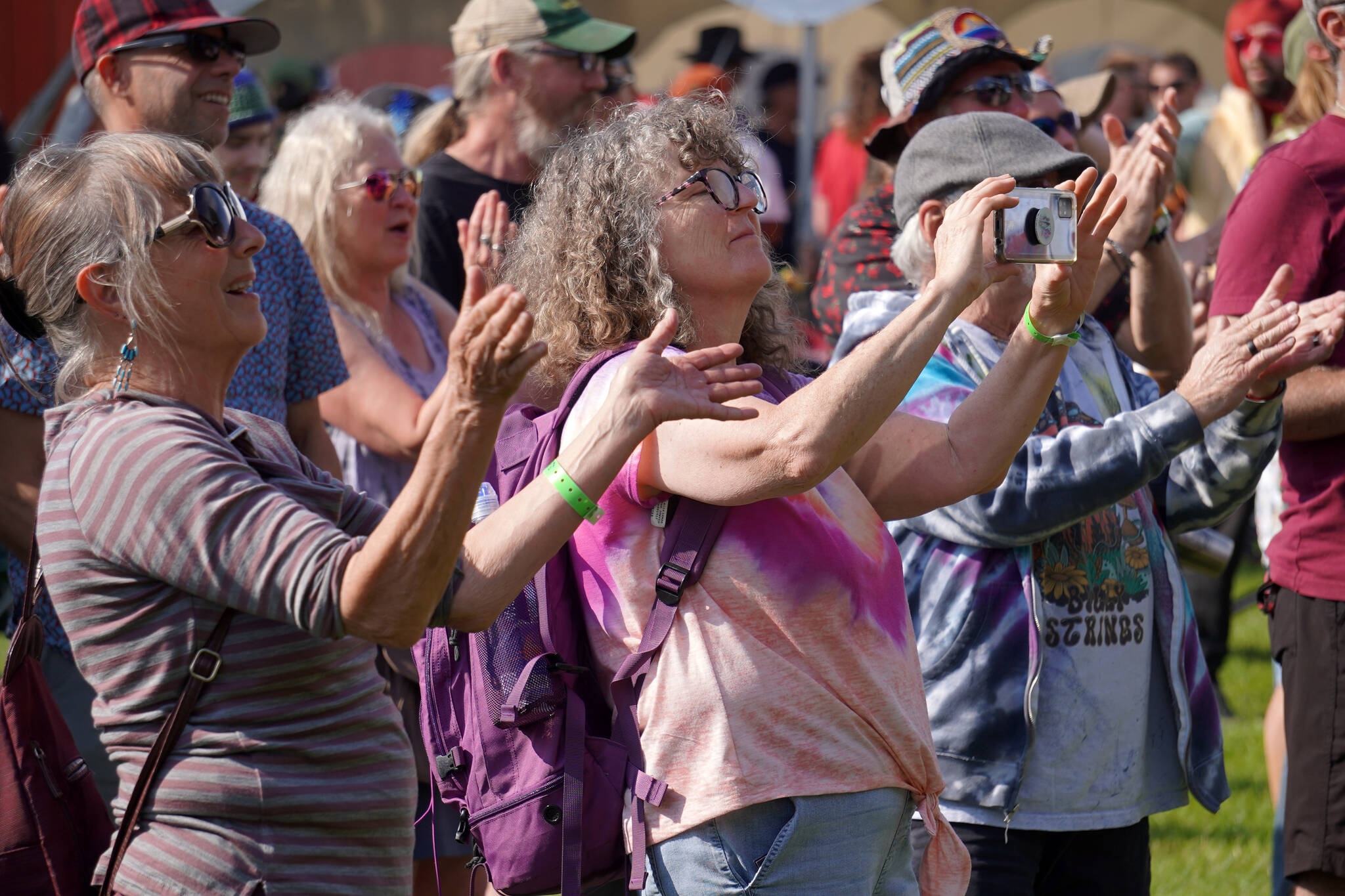 Attendees clap, record and dance along to a performance by Moonalice on the Ocean Stage at Salmonfest in Ninilchik, Alaska, on Friday, Aug. 4, 2023. (Jake Dye/Peninsula Clarion)
